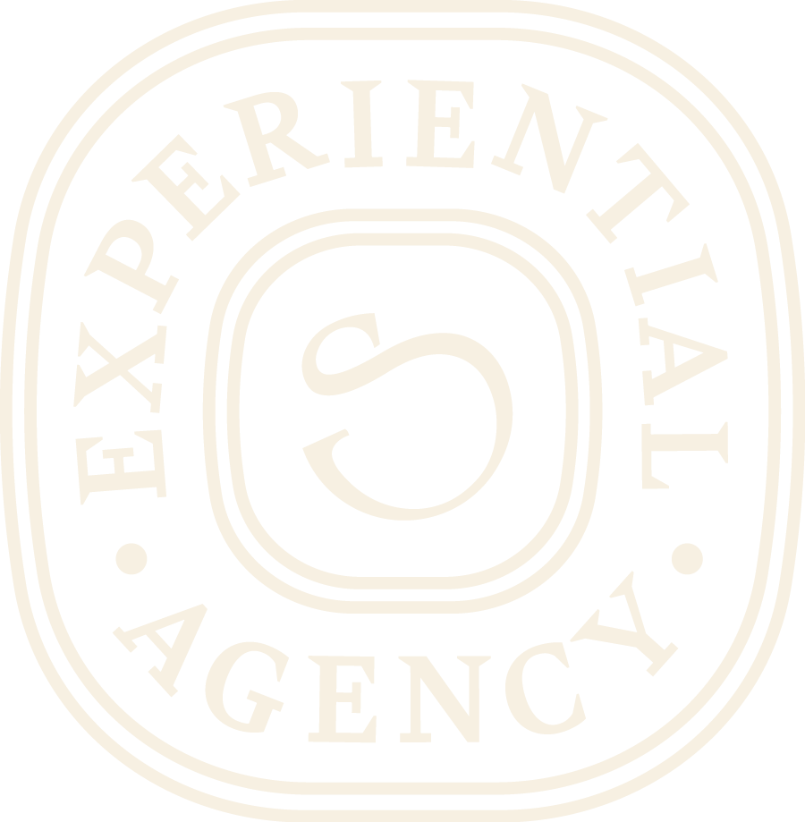 A black and white logo featuring the text 'EXPERIENTIAL AGENCY' with a stylized 'S' in the center.