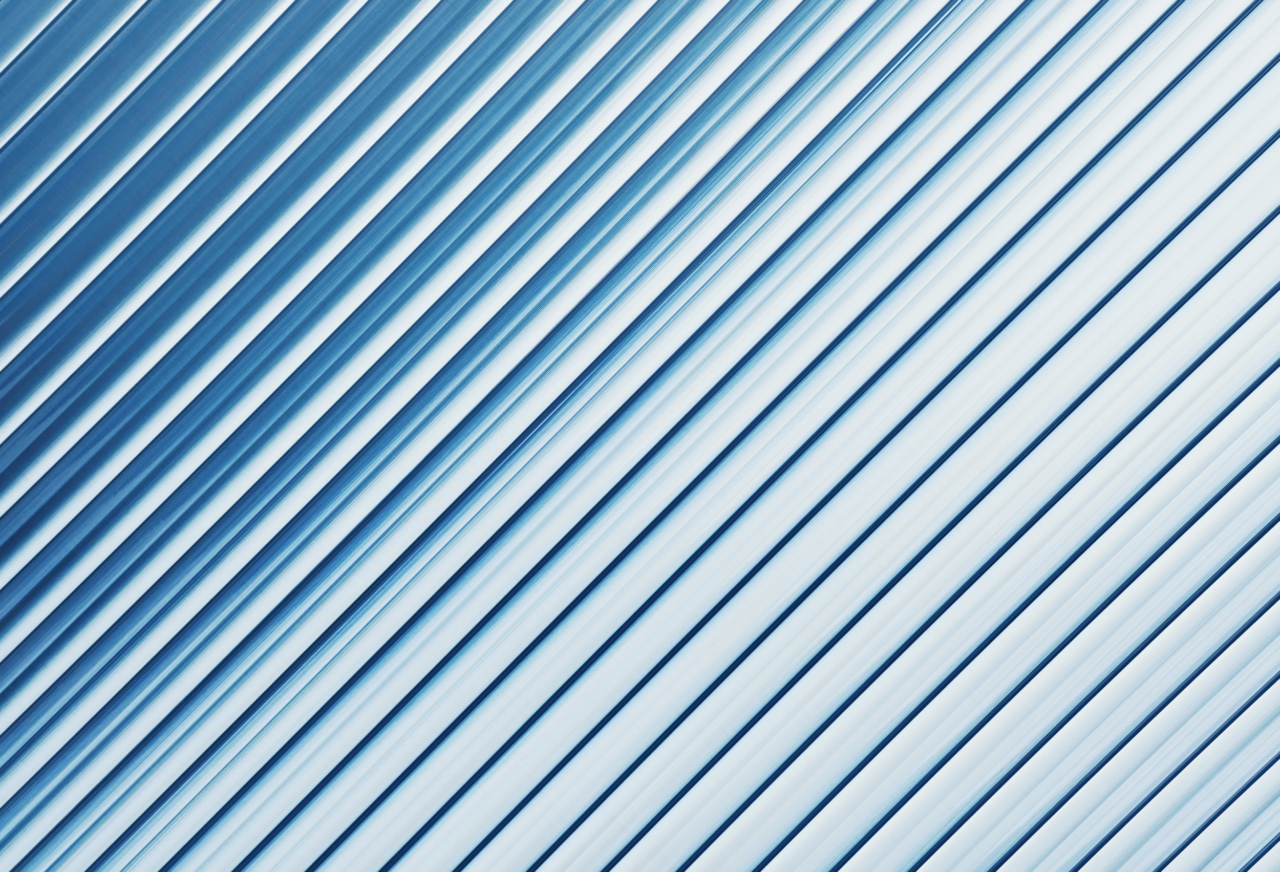 Close-up of metallic, striped patterns with diagonal lines and shades of blue and white.