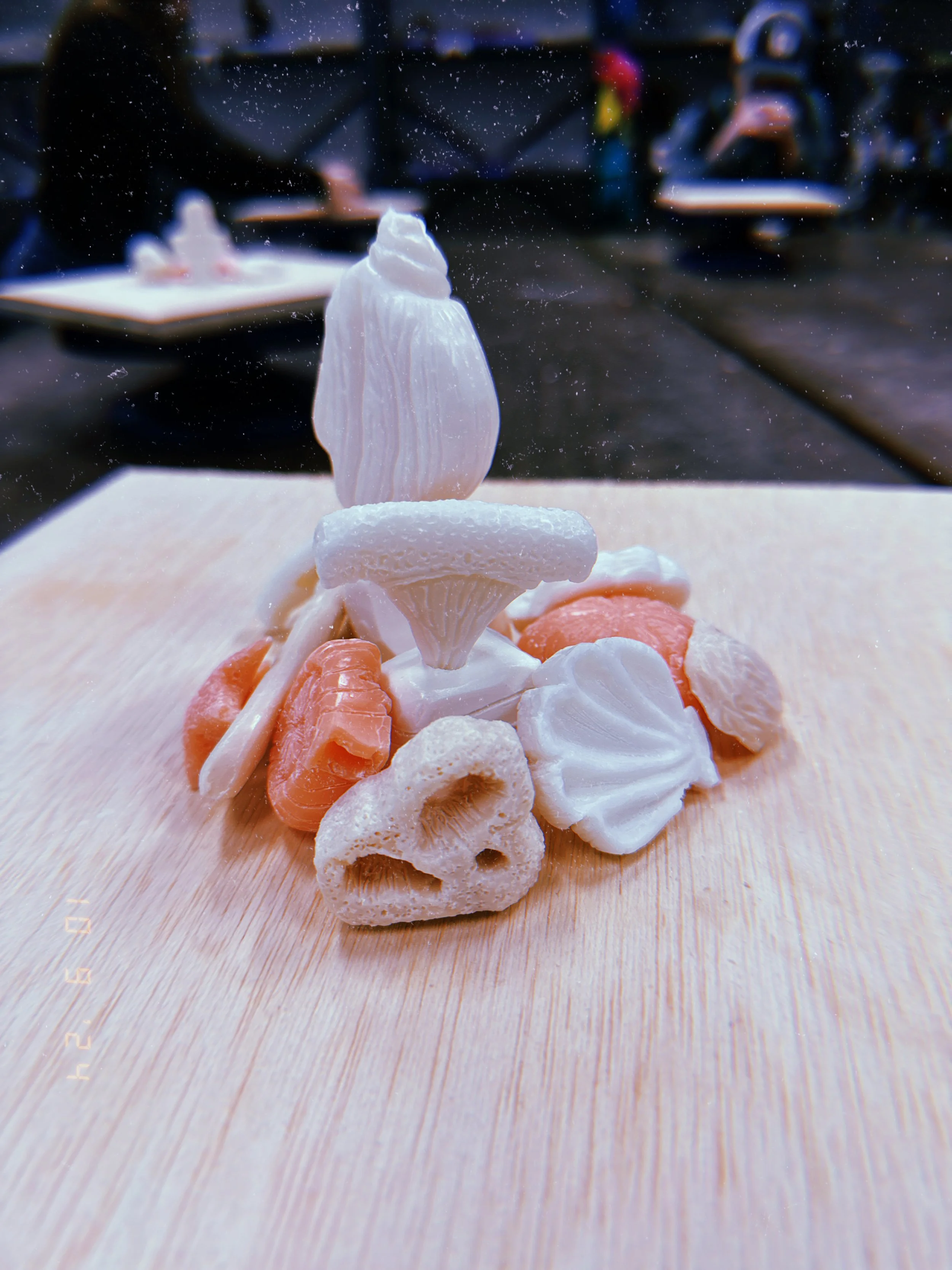 Close-up view of a vegetable carving of a mushroom, with various other vegetables and vegetable carvings around it.