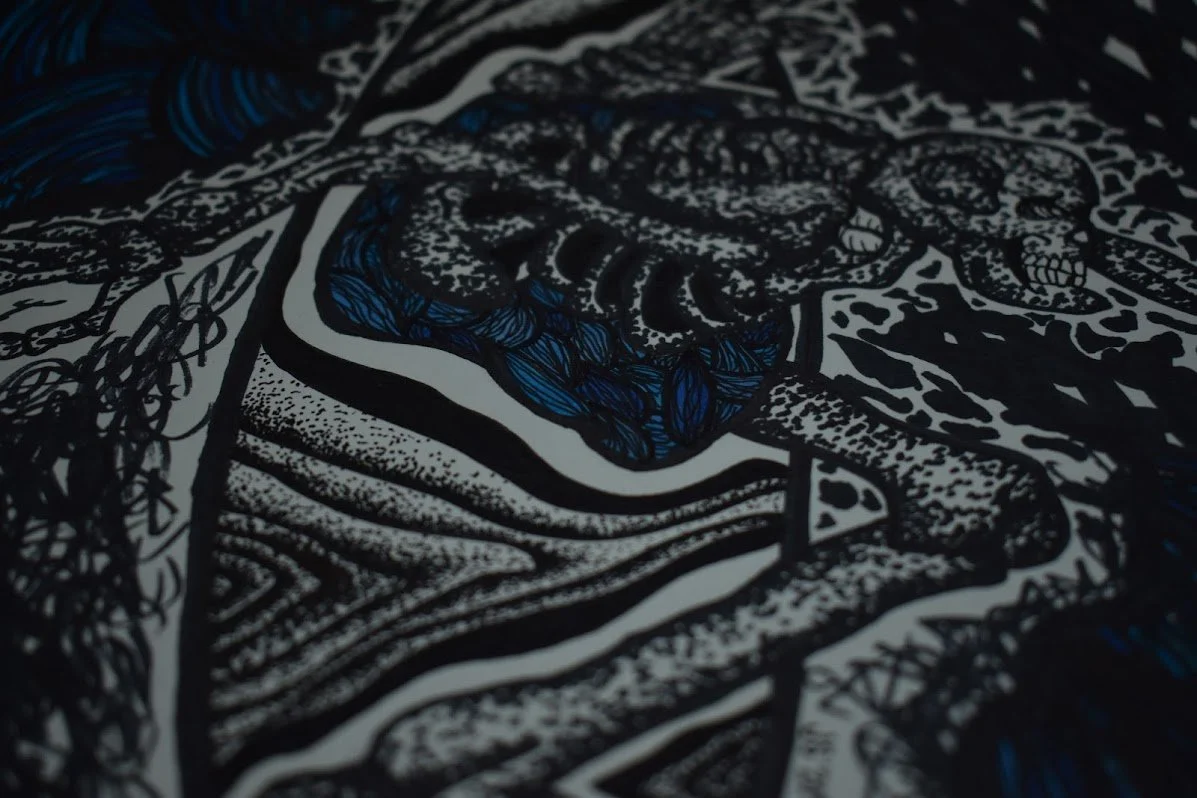 A close-up view of a detailed black and white illustration on fabric, featuring a tiger with blue accents, surrounded by intricate patterns and designs.
