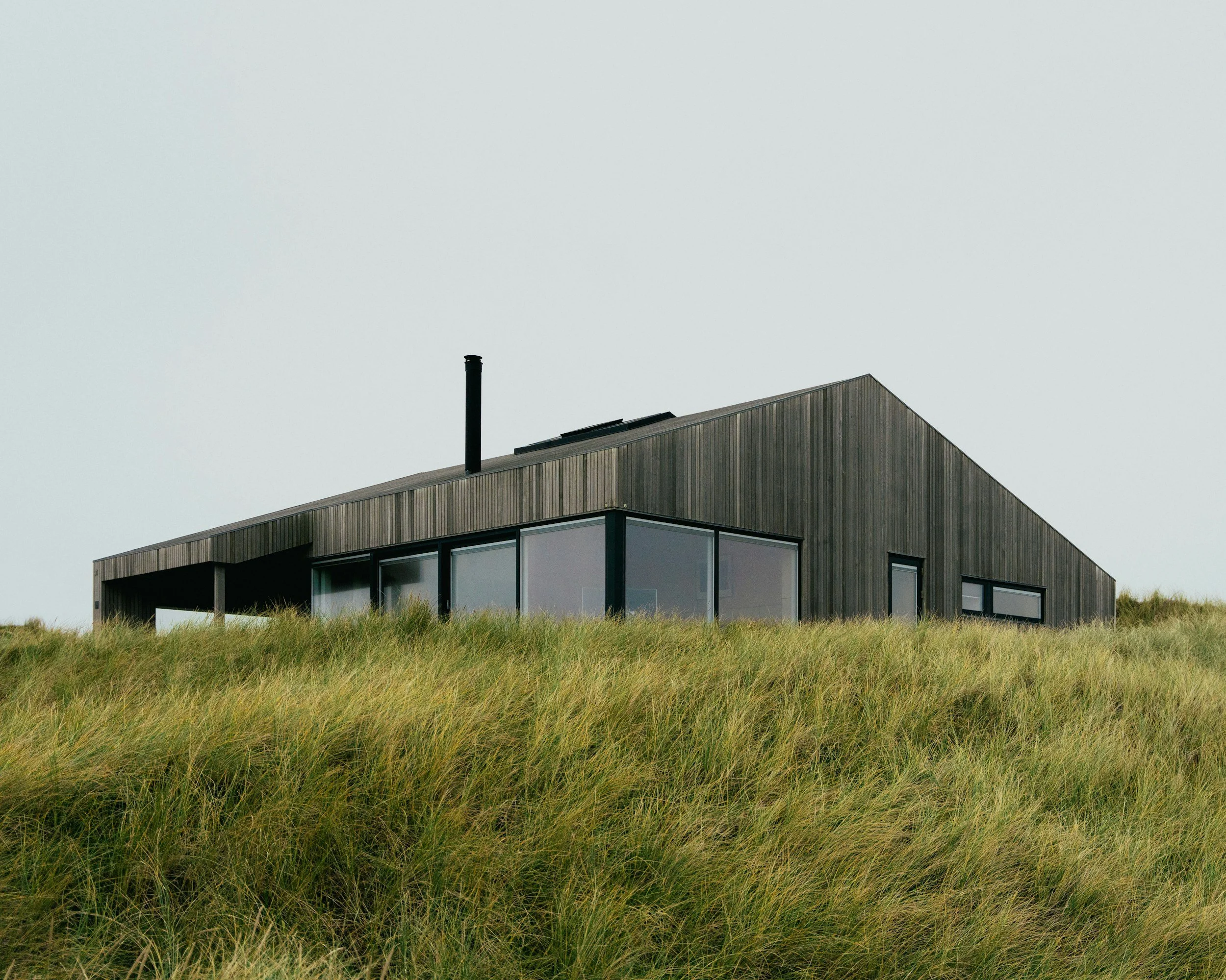 modern nordic style cabin tucked in to the mountain grasses