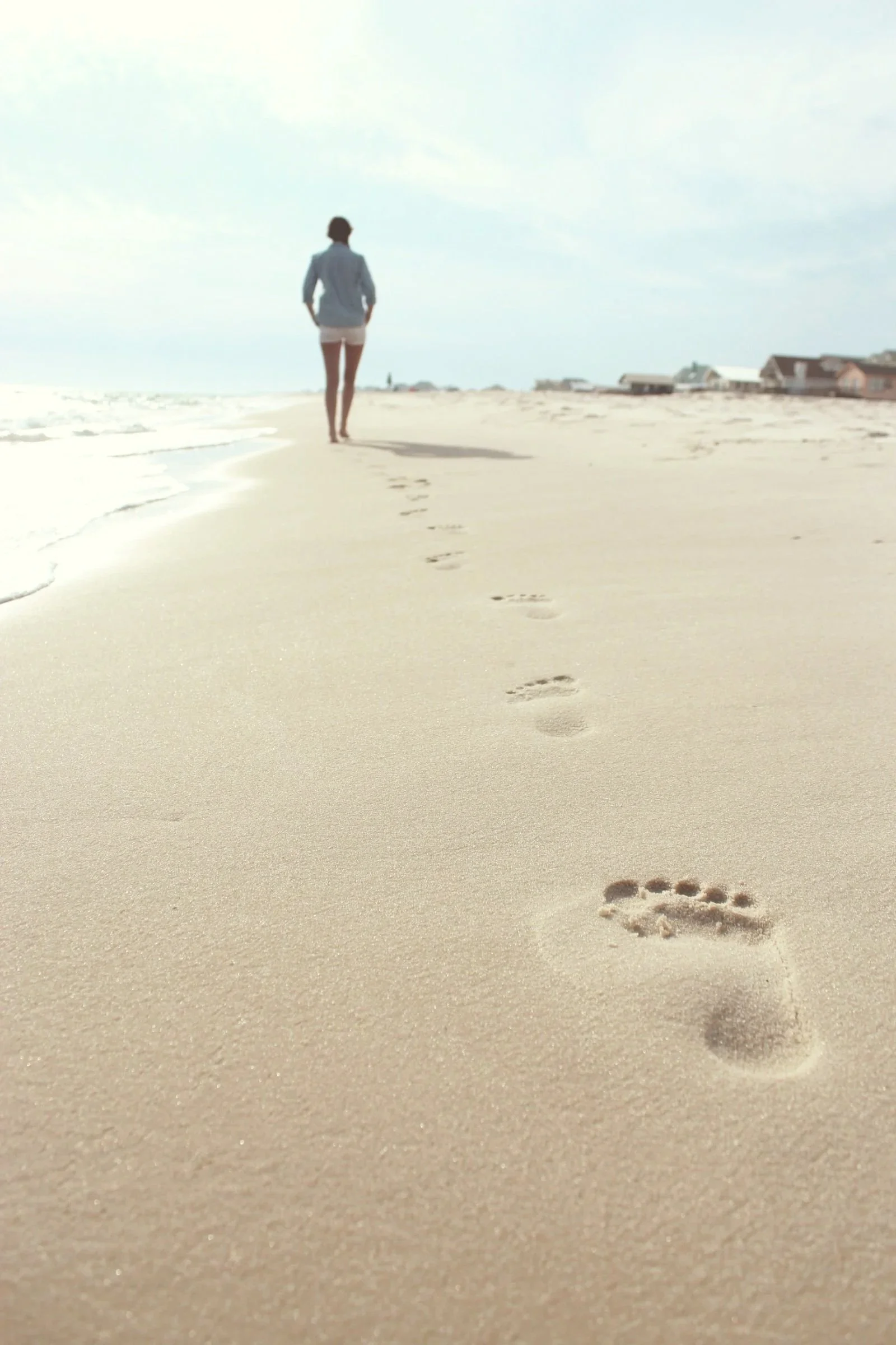 Woman walking alone on the beach depicting the loneliness that perimenopause can cause