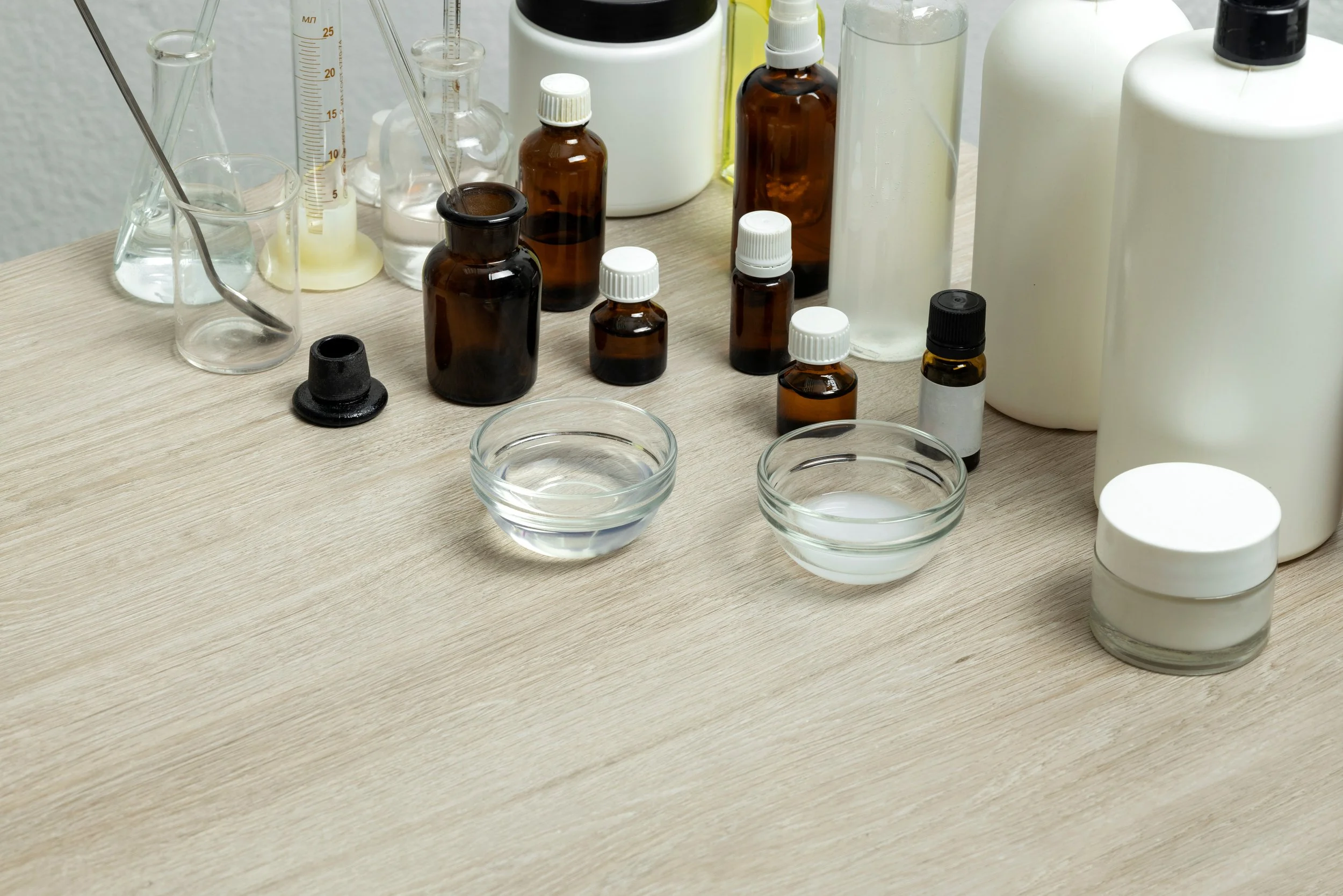 A collection vials, beakers and glass bowls with various liquids and chemicals for a home-based laboratory.