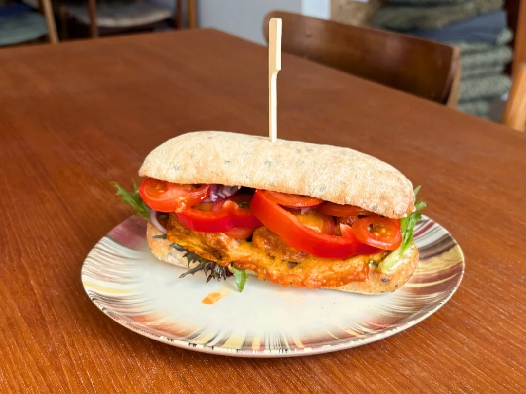 Sandwich med kylling, tomat, rød peberfrugt og salat.