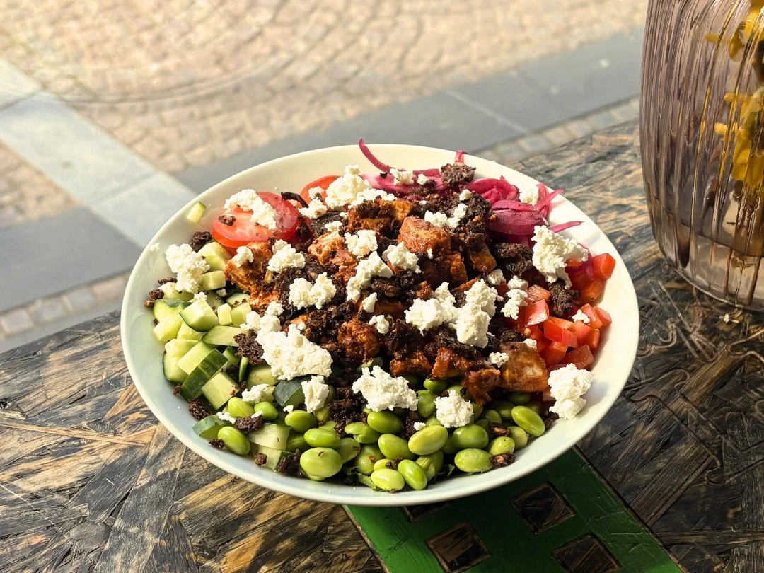 Kyllingesalat med tomater, agurk, ost, kylling, peberfrugt. syltede rødløg, edamamebønner og rugbrødsknas.