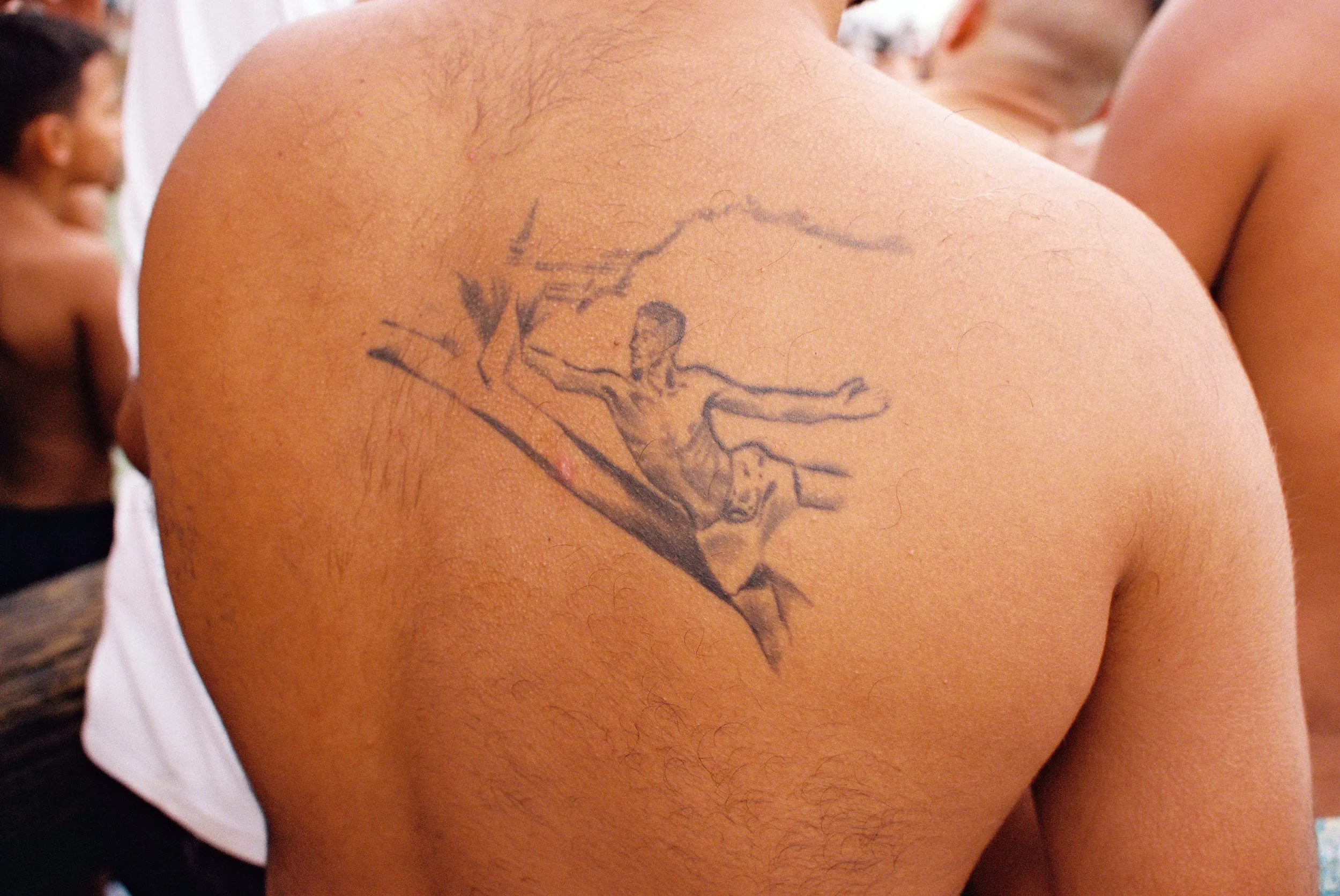 Tatuaje en el hombro de un hombre que representa a Jesús crucificado.