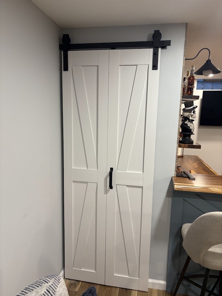White sliding barn door with black hardware in a modern home interior.