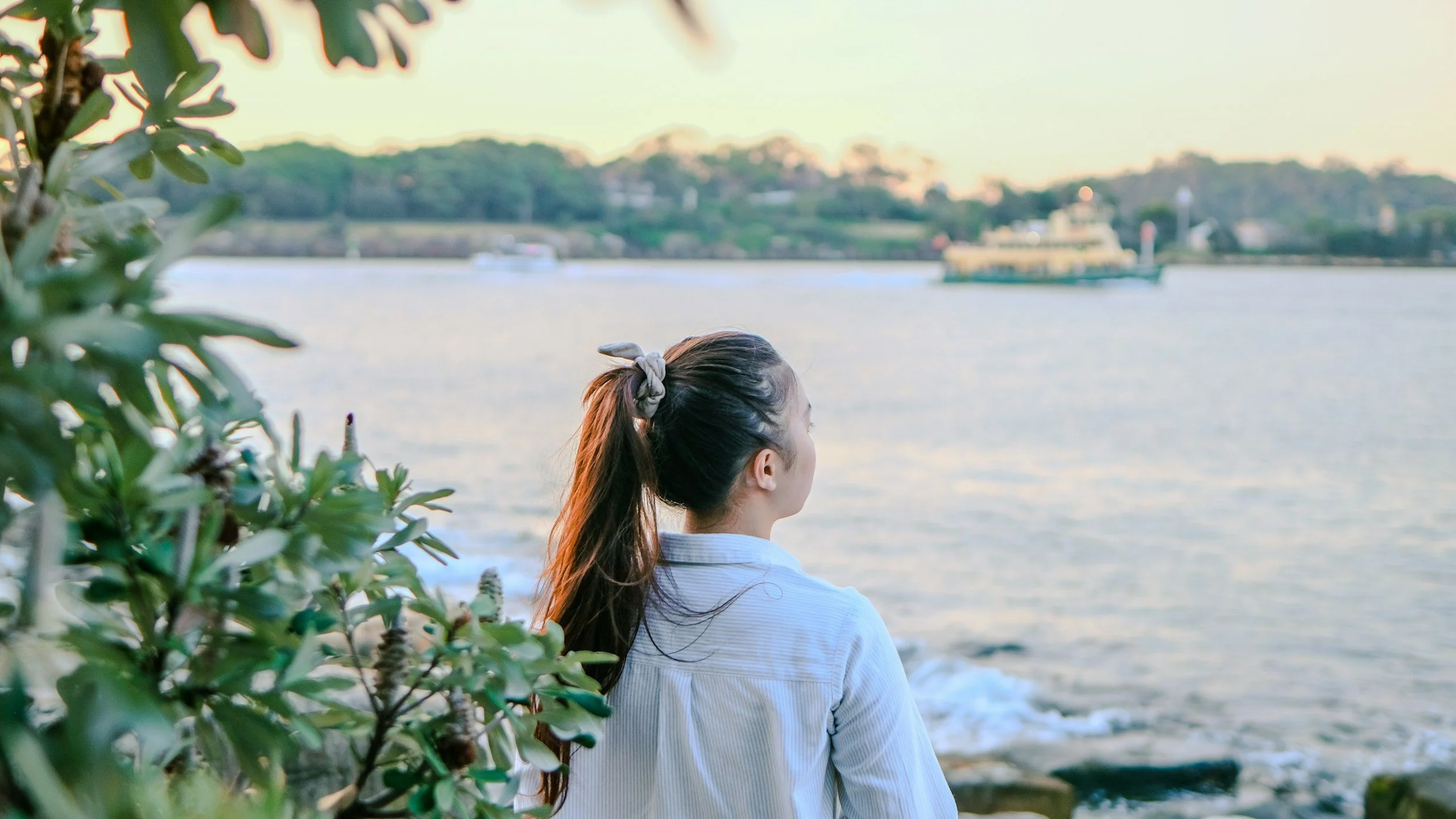 A woman in a moment of reflection with a scenic background.