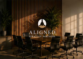 Conference room with a wooden wall, potted plants, and a logo for 'Aligned Strategy & Finance' projected on the wall.