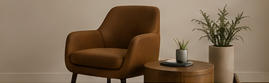 Living room corner with brown armchair, round wooden side table, potted plant, and decorative bowl.