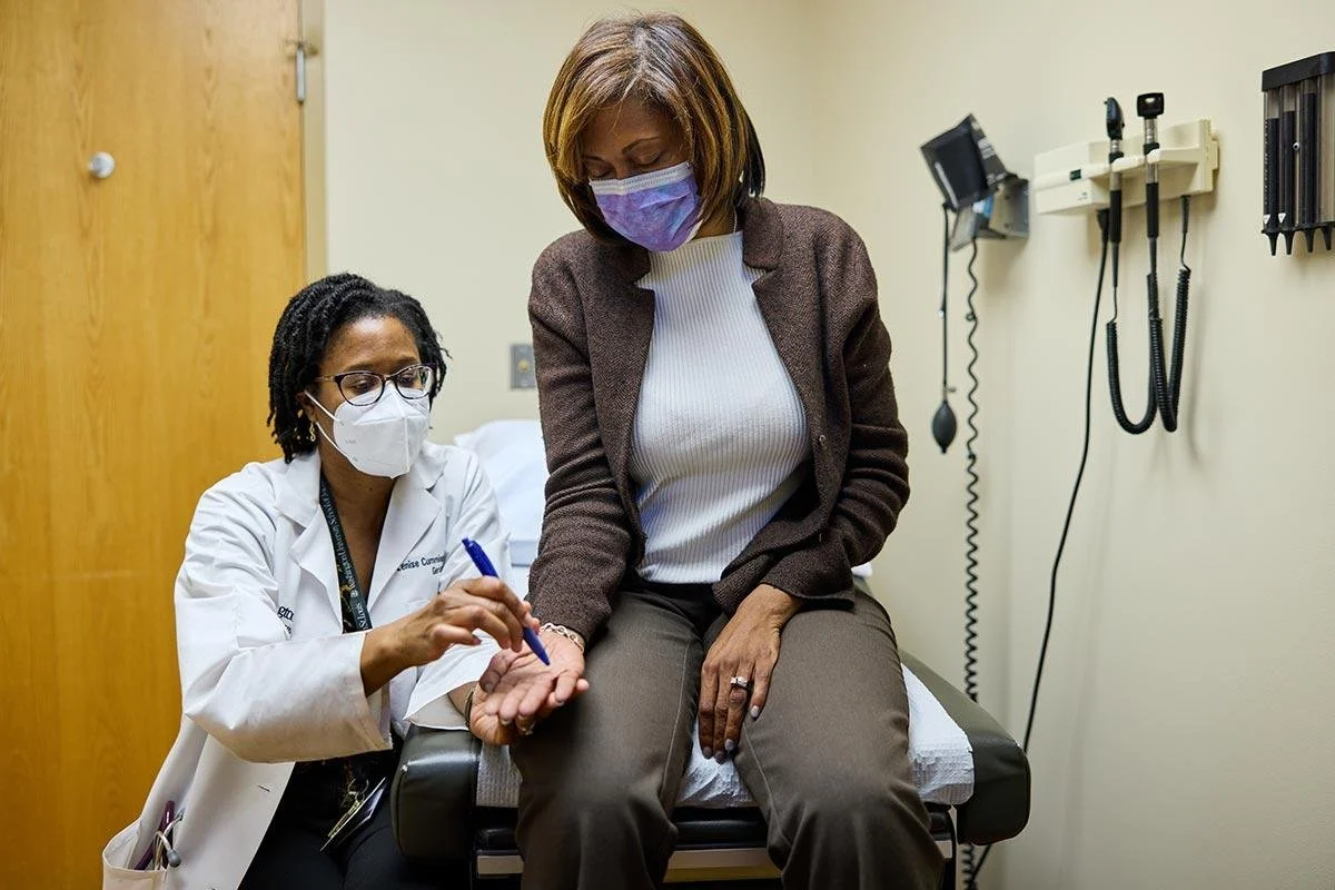 A healthcare professional prepares to give a patient a vaccination in a clinical setting.