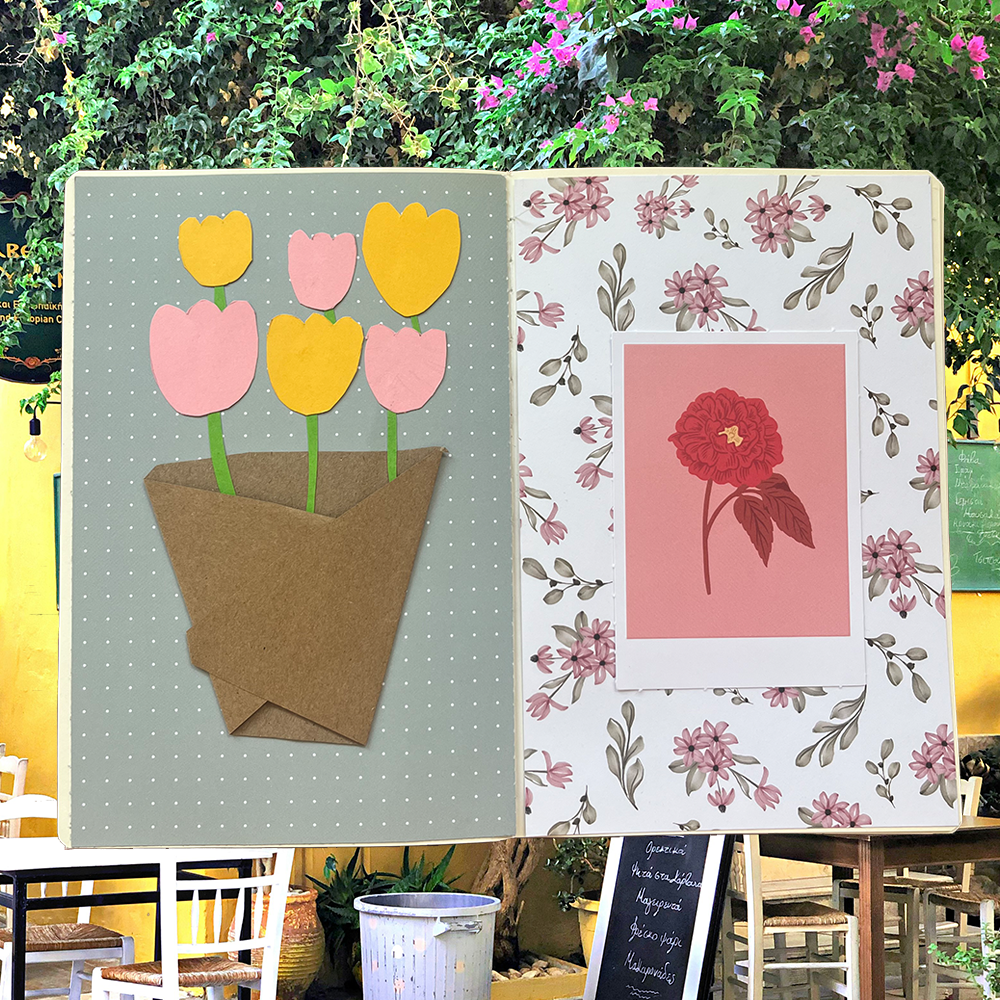an open journal with a paper flower bouquet on the left side and a picture of a flower on the left side