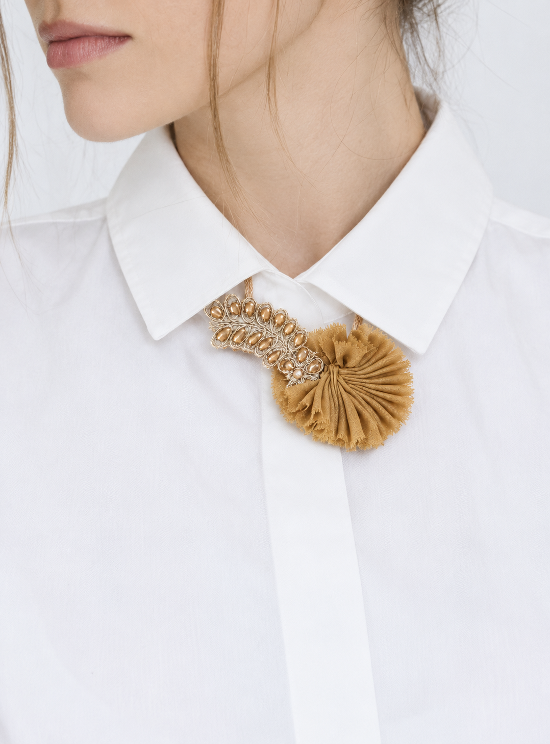 Portrait au collier moutarde sur chemise blanche.png
