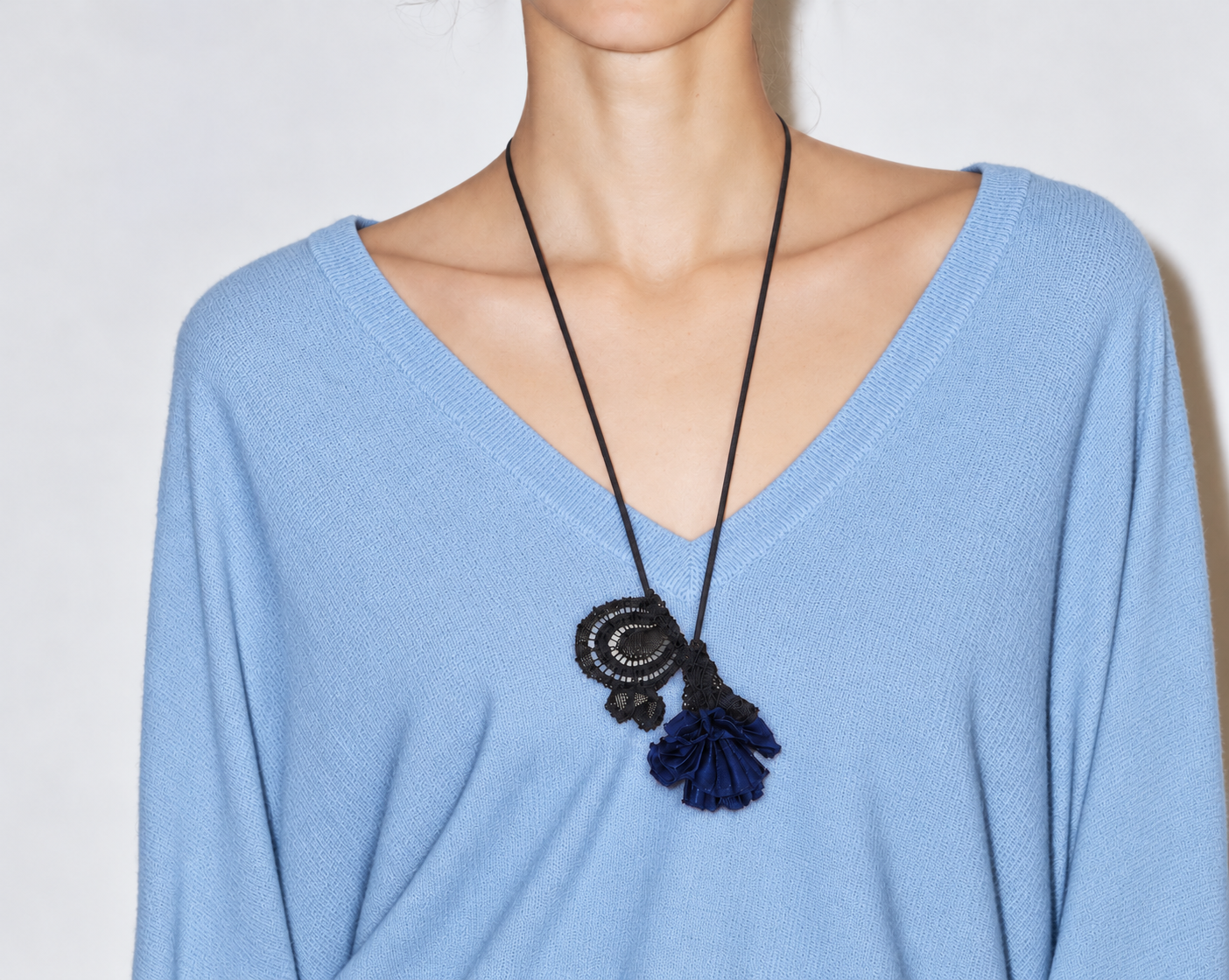 Pendentif fleuri sur pull bleu ciel.png