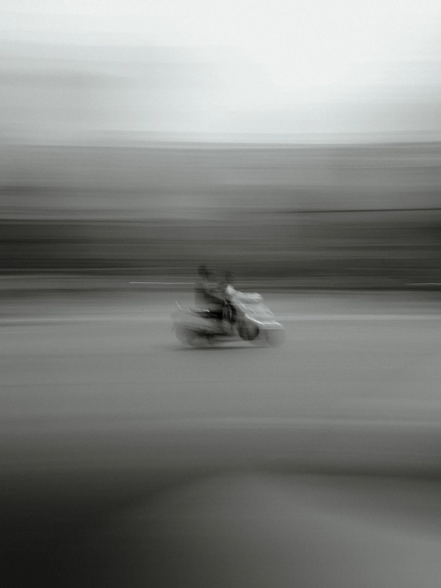 A motorcycle moving at high speed on an open road, creating motion blur in the image.