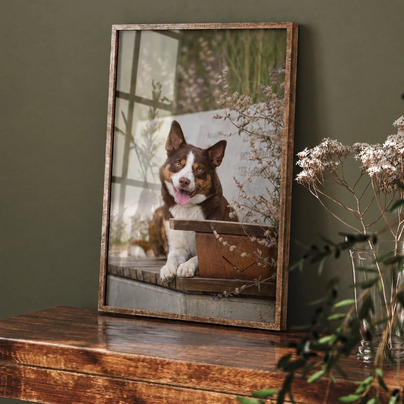 Framed dog portrait of a brown and white dog resting on a wooden console table