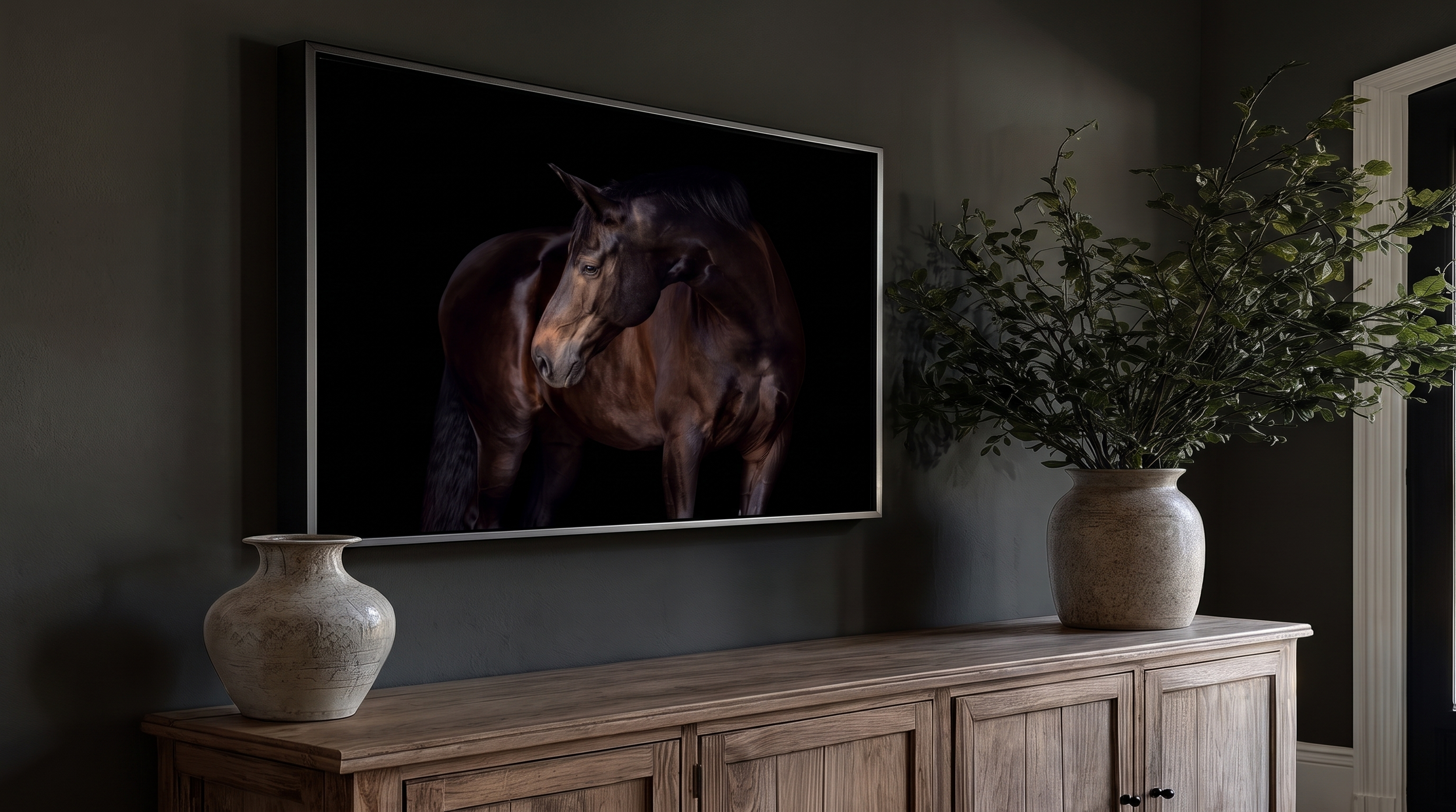 Elegant dark interior with framed horse artwork above a wooden sideboard, decorated with ceramic vases and a leafy potted plant.