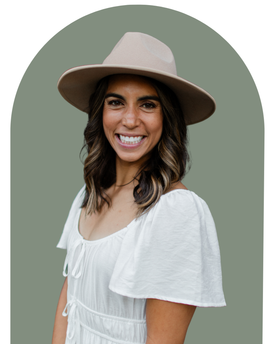 A woman smiling, wearing a beige wide-brimmed hat and a white blouse, against a muted green background.