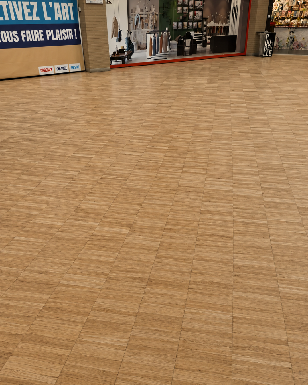 Vue d’ensemble d’un parquet massif rénové après ponçage et vitrification dans les espaces communs du centre commercial d’Éragny.