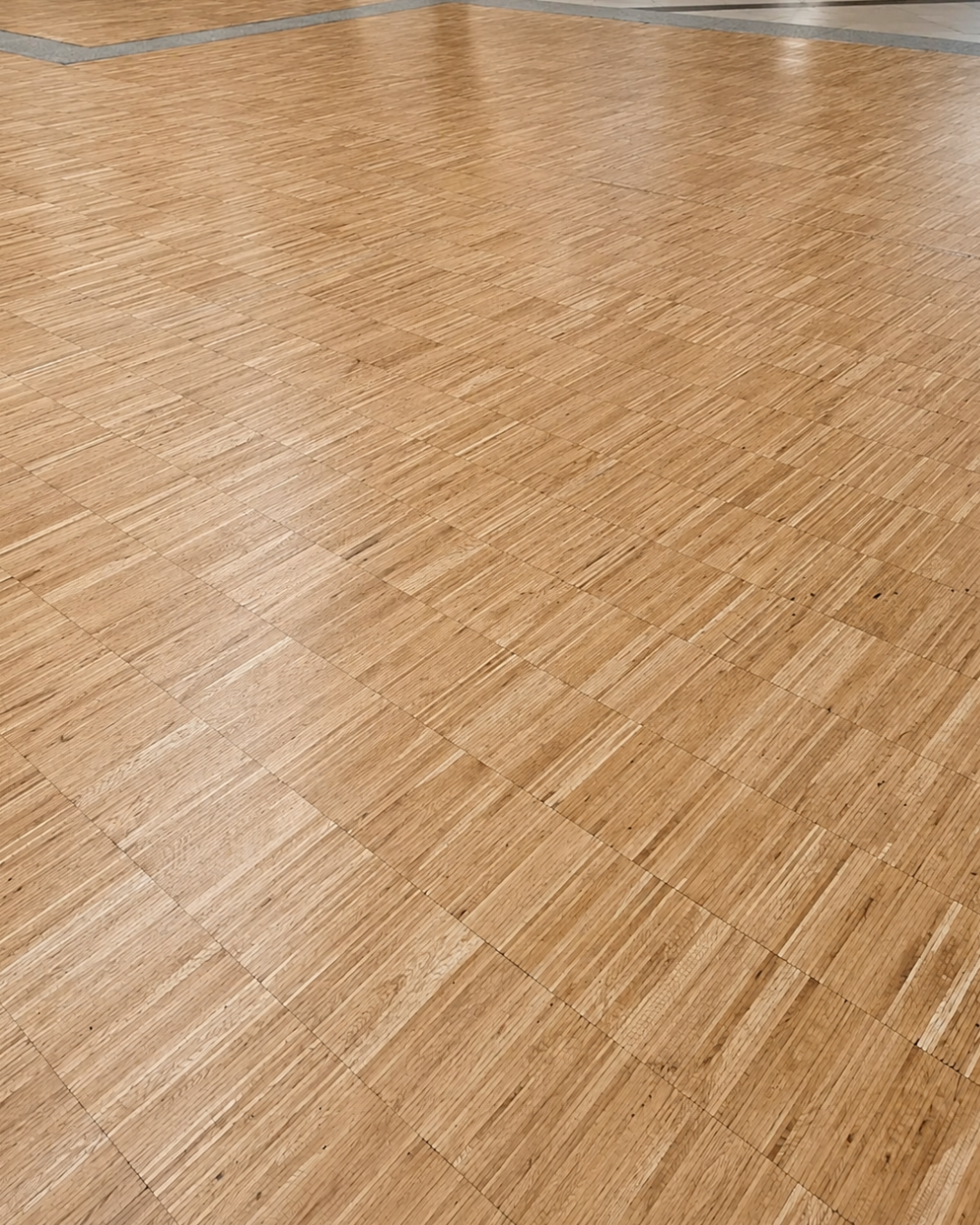 Rénovation d’un parquet en bois avec ponçage et finition vitrifiée dans un centre commercial à Éragny.