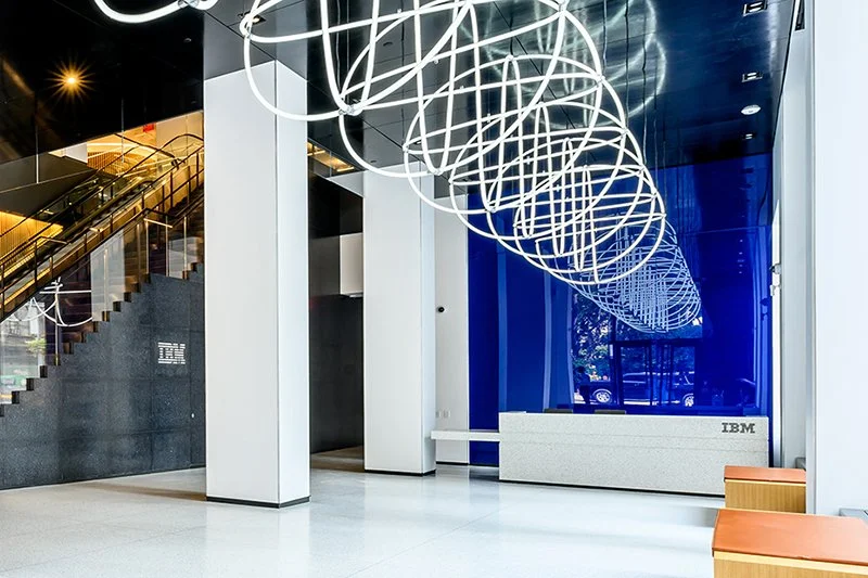 Lobby at One Madison Avenue with sculpture hanging from ceiling, blue wall, and IBM logo