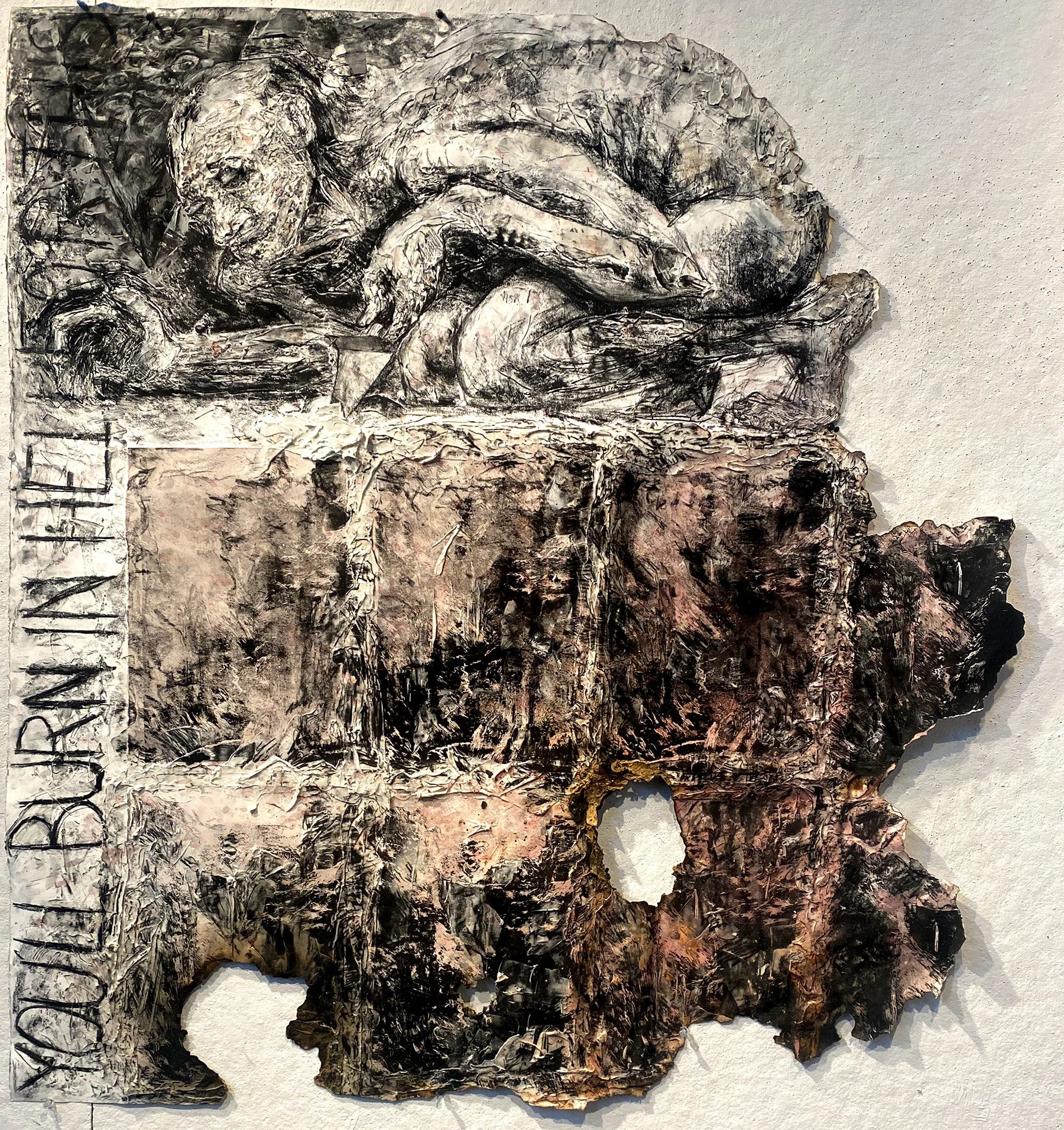 A mixed media artwork depicting a reclining nude figure in a sketchy, expressive style using black and white tones with hints of pink and brown. The focus is on the figure's relaxed posture and textured surface, with some abstract elements and illegible writing on the left side.