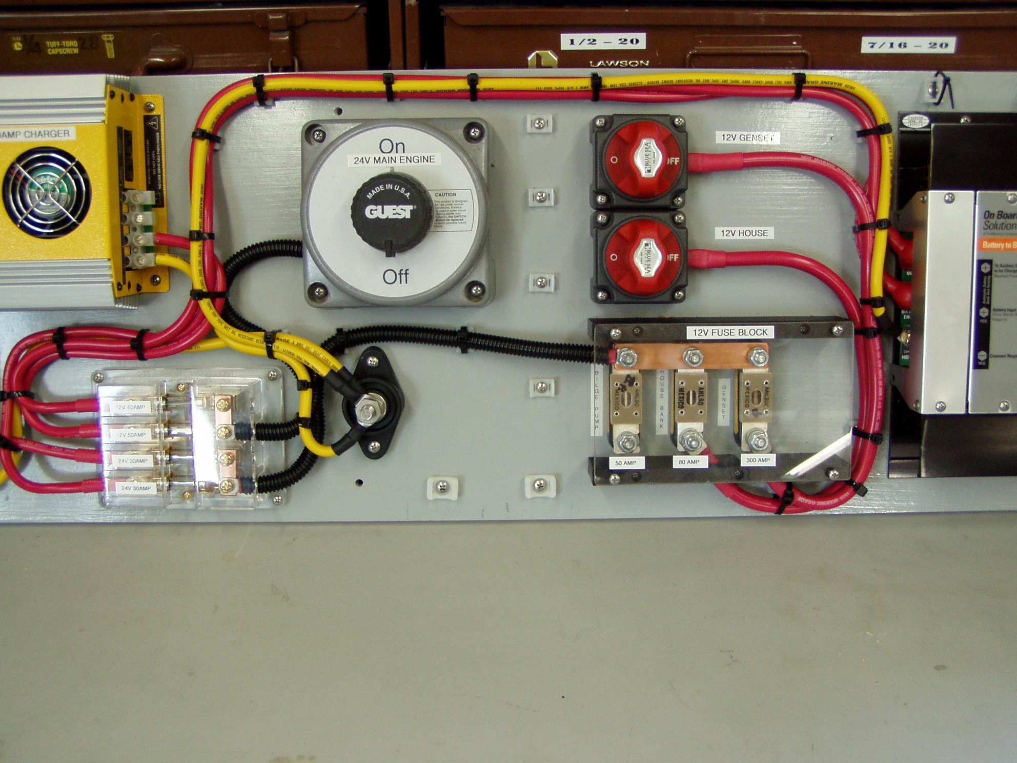 An electrical control panel with various switches, labels, and wiring including a large switch labeled "On 24V Main Engine," two red switches, and multiple fuse blocks.