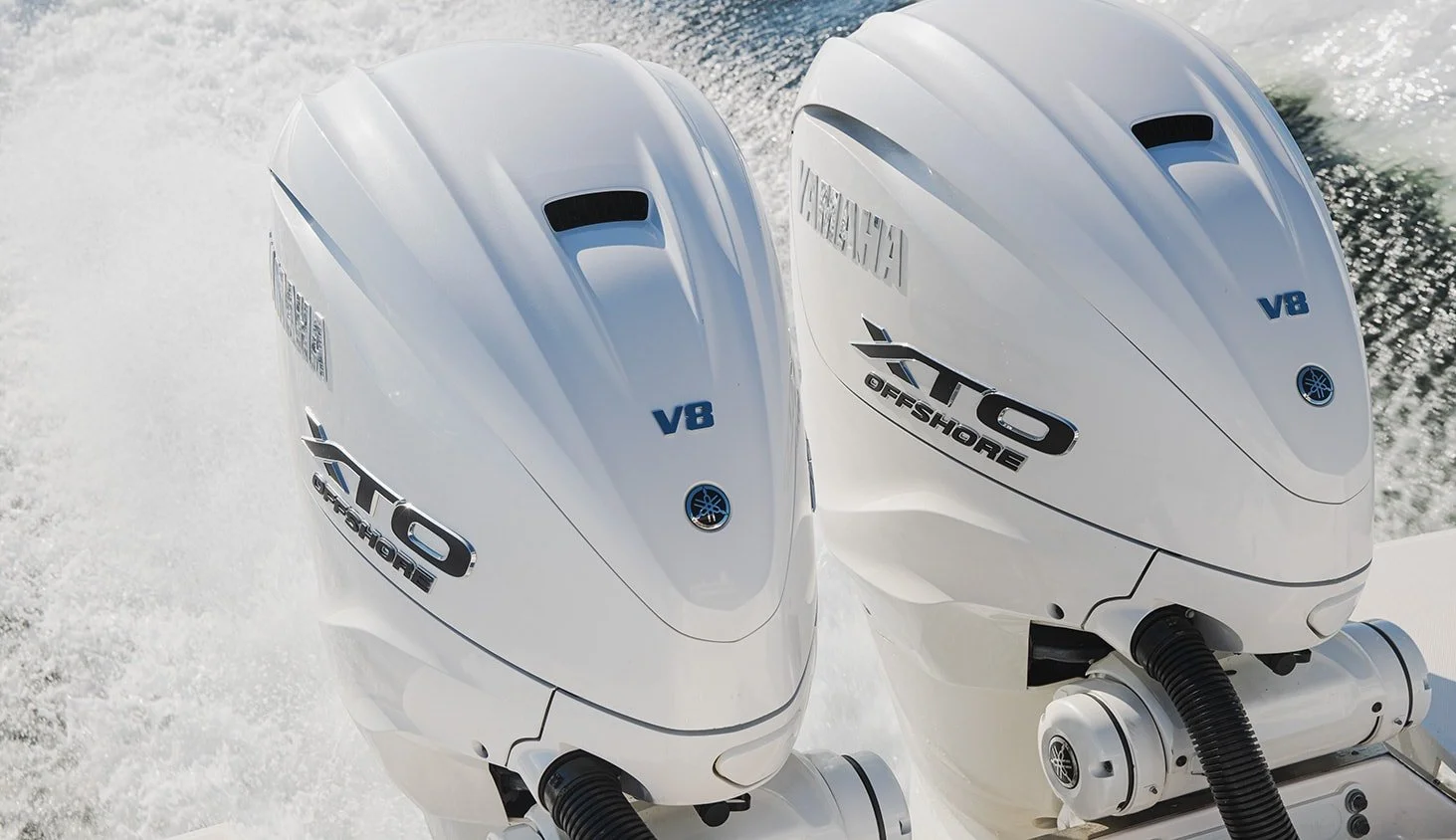 Two white Yamaha VF8 Outboard motors on a boat, with water in the background.