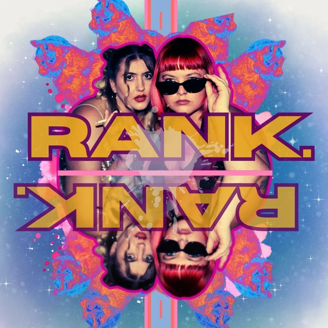 Colorful digital artwork featuring two women with contrasting styles, with abstract tiger faces in the background. The text "RANK. RANK" is prominently displayed in bold yellow letters with purple outlines, mirrored upside down below. One woman has dark hair styled in a half-up, half-down look, while the other has straight red hair with bangs and wears sunglasses. The background is a blend of blue and pink hues with star-like sparkles.
