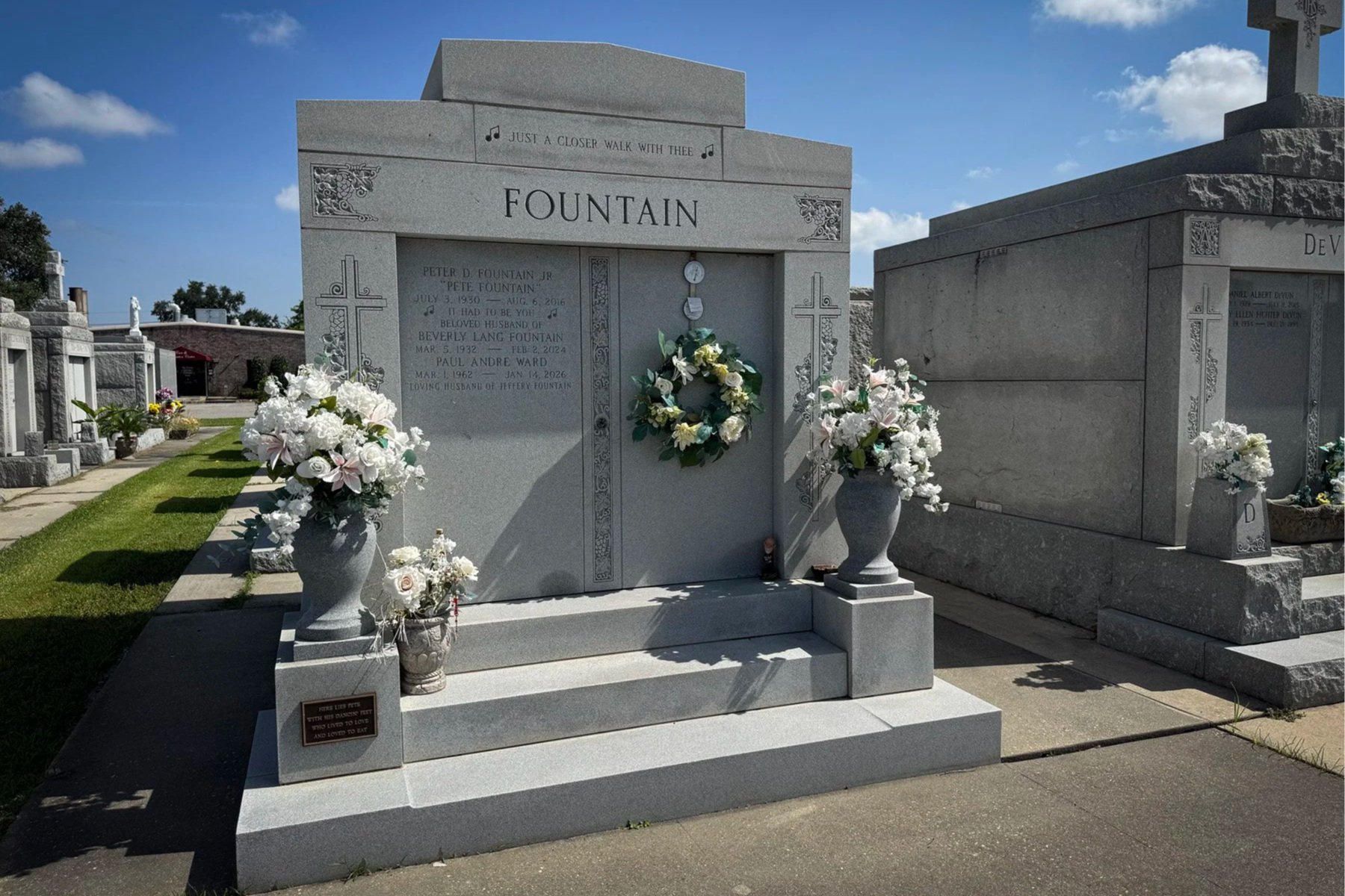 Pete Fountain family tomb decorated with flowers and engraved with musical notes in Metairie Cemetery.