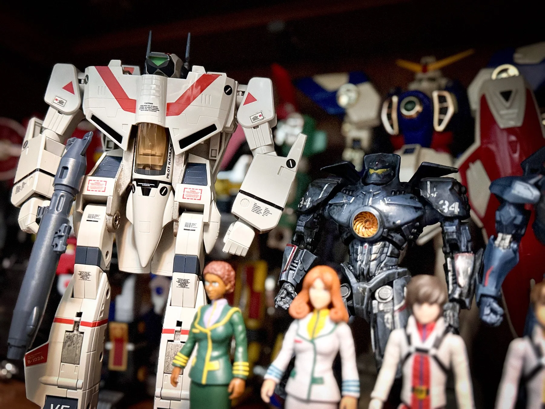 VF-1 Valkyrie from Macross displayed with science fiction figures and robots in Marco's display room.