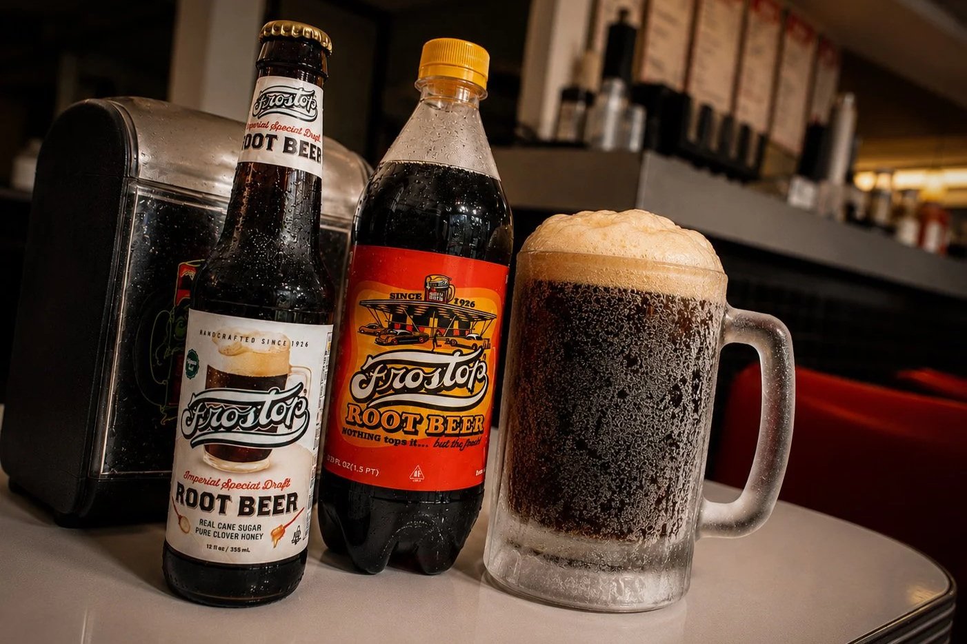 Bottles of Frostop Root Beer displayed on a diner table at Ted's Frostop in New Orleans, featuring vintage and modern label designs that represent the brand's transition from drive-in restaurants to grocery store shelves.