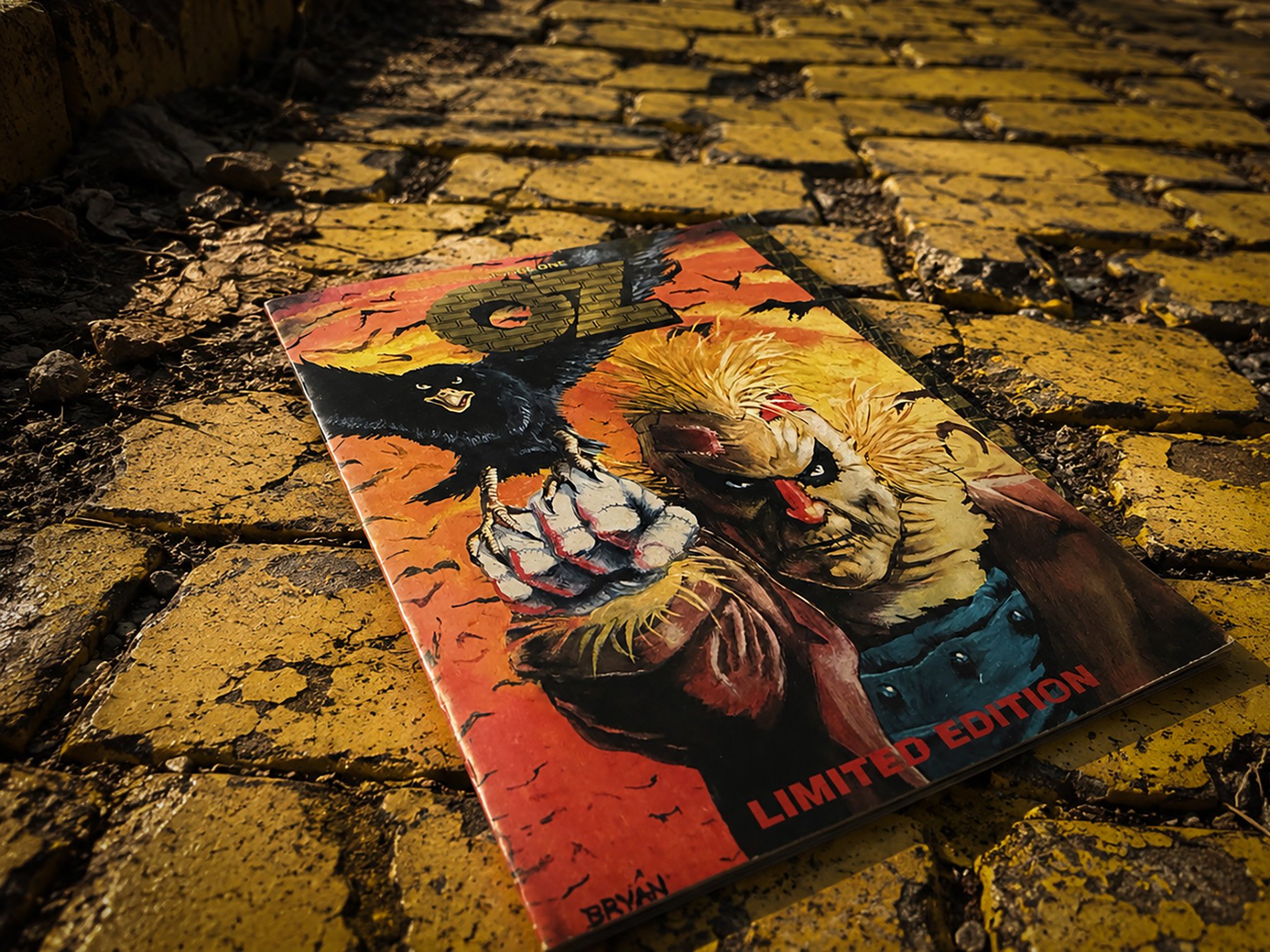 Signed limited edition of Oz #1 from Caliber Comics photographed on a weathered Yellow Brick Road, symbolizing the beginning of the publisher's dark reinterpretation of L. Frank Baum's Oz.