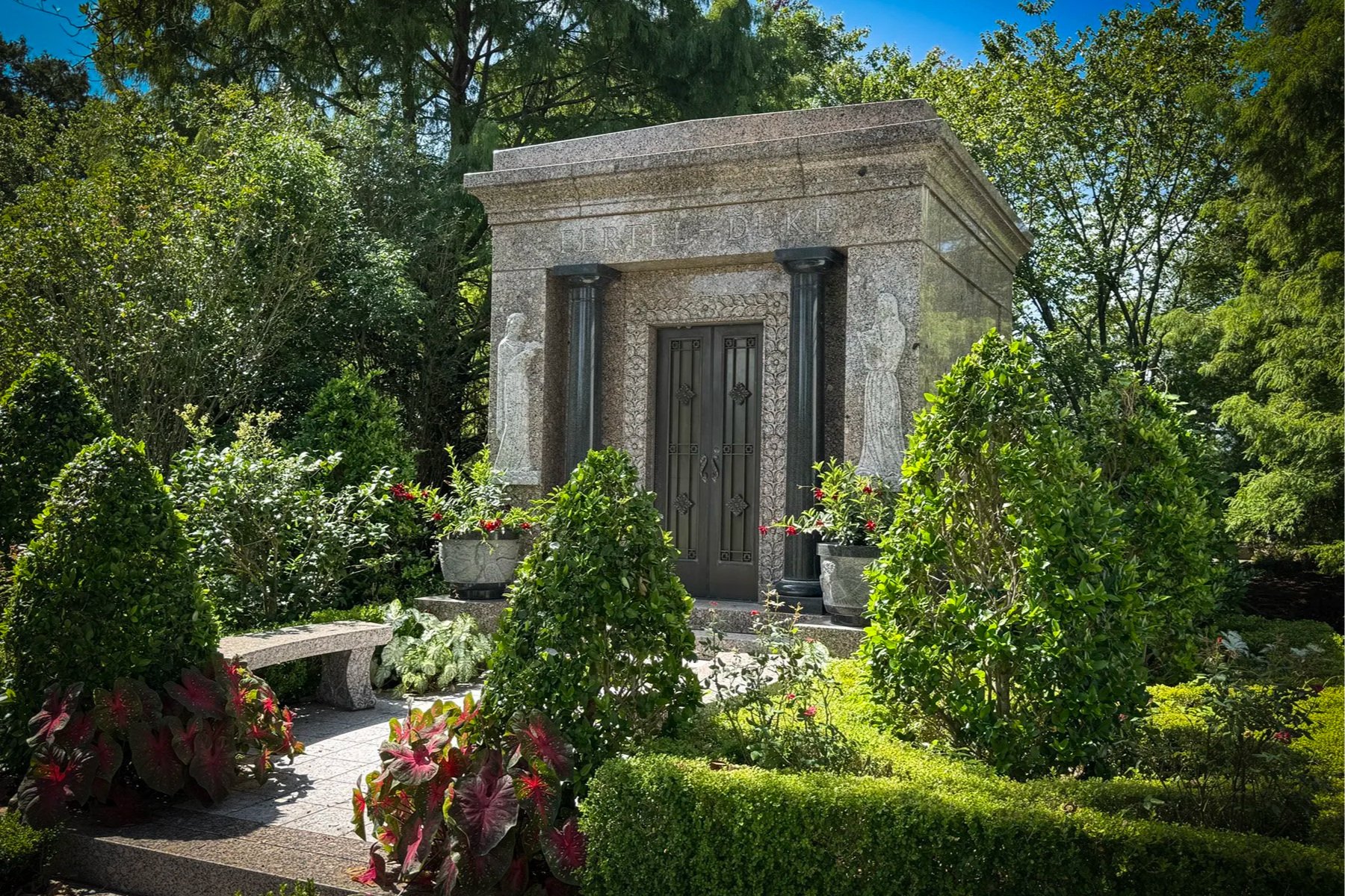 Fertel-Duke family mausoleum with black columns and angel mosaics in Metairie Cemetery.