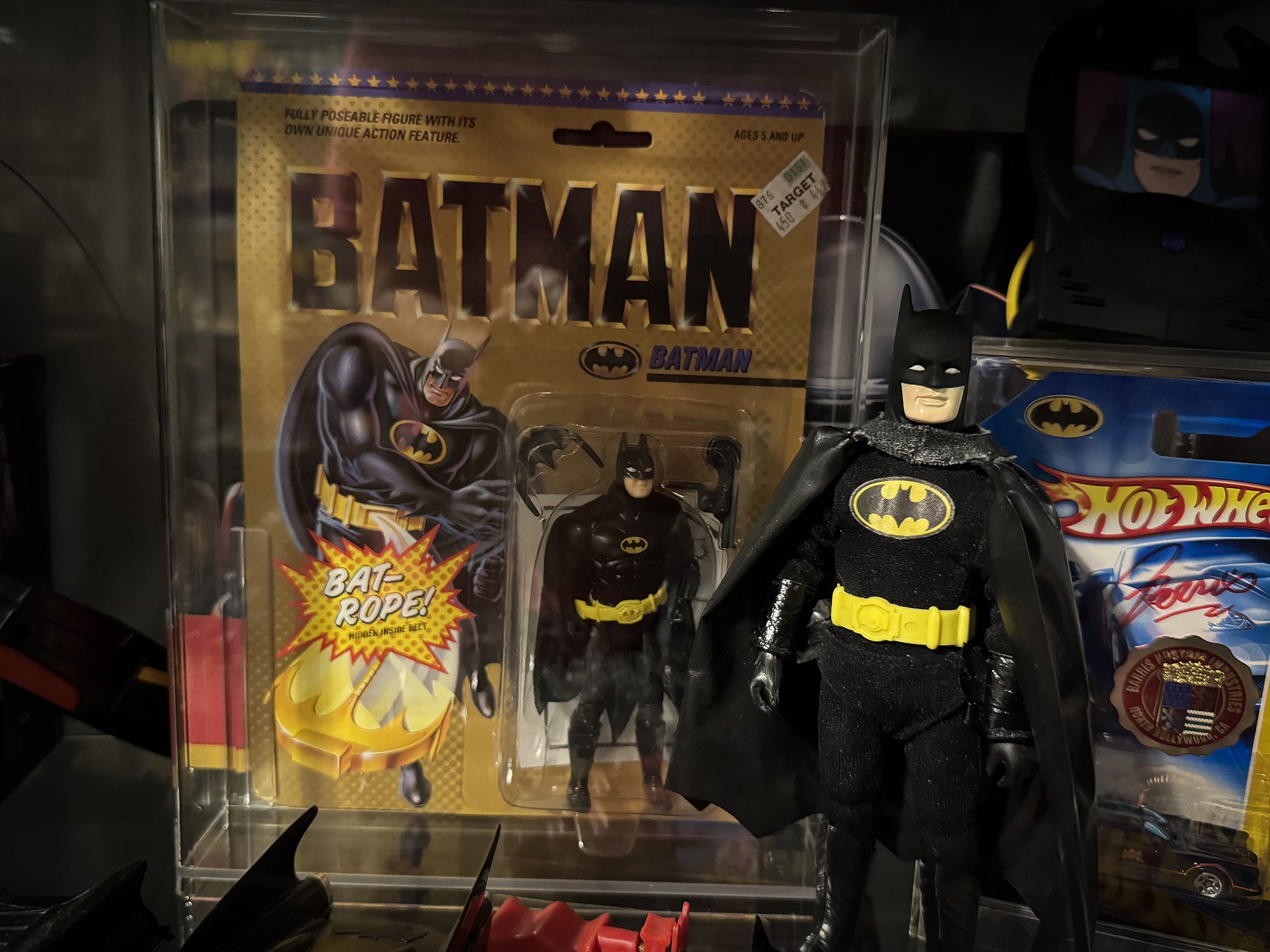 An unopened Toy Biz Batman (1989) action figure with the Bat-Rope feature displayed next to a loose Batman figure on a collector's shelf.