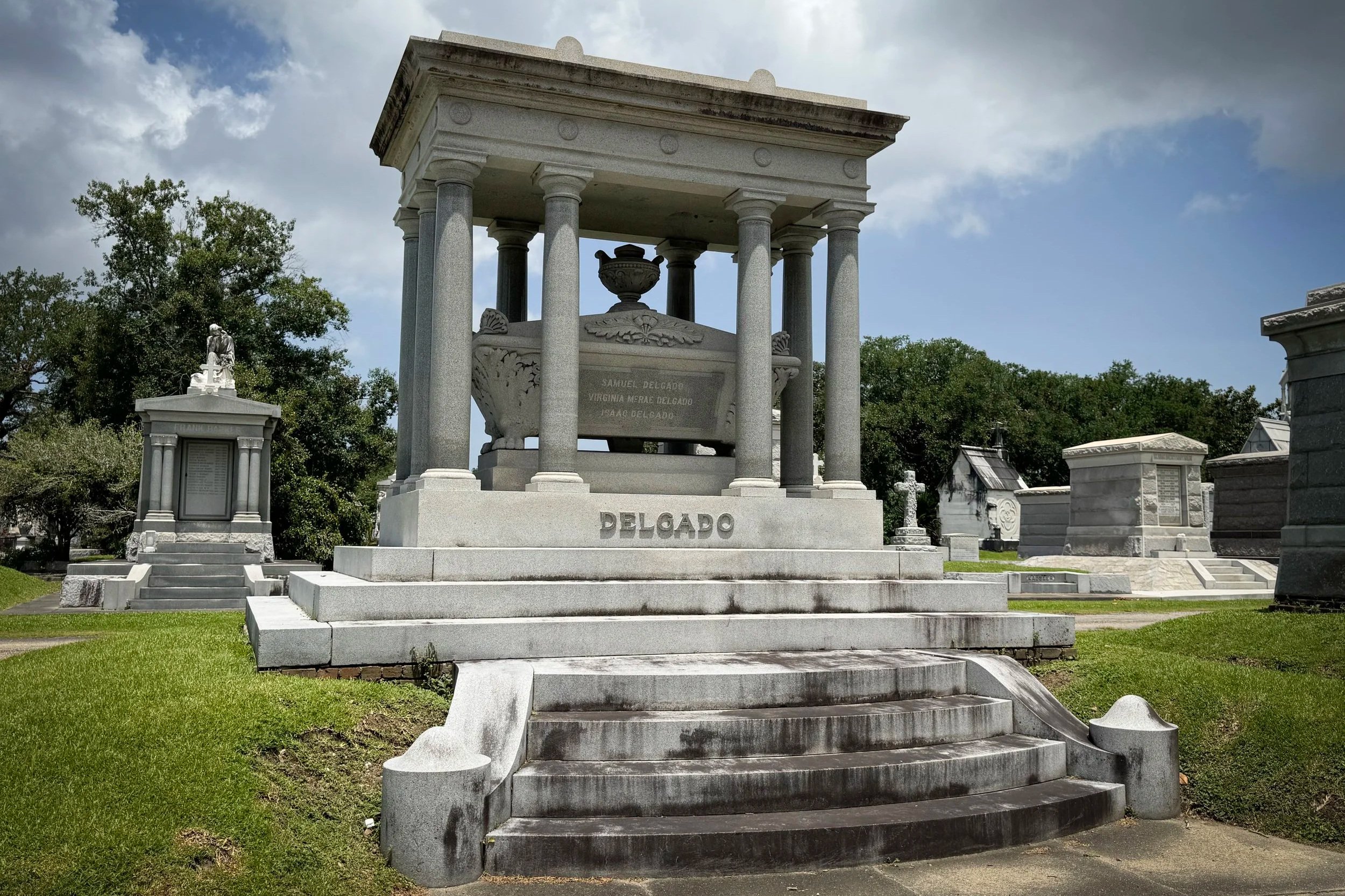 Grand columned Isaac Delgado family tomb with curved steps in Metairie Cemetery.