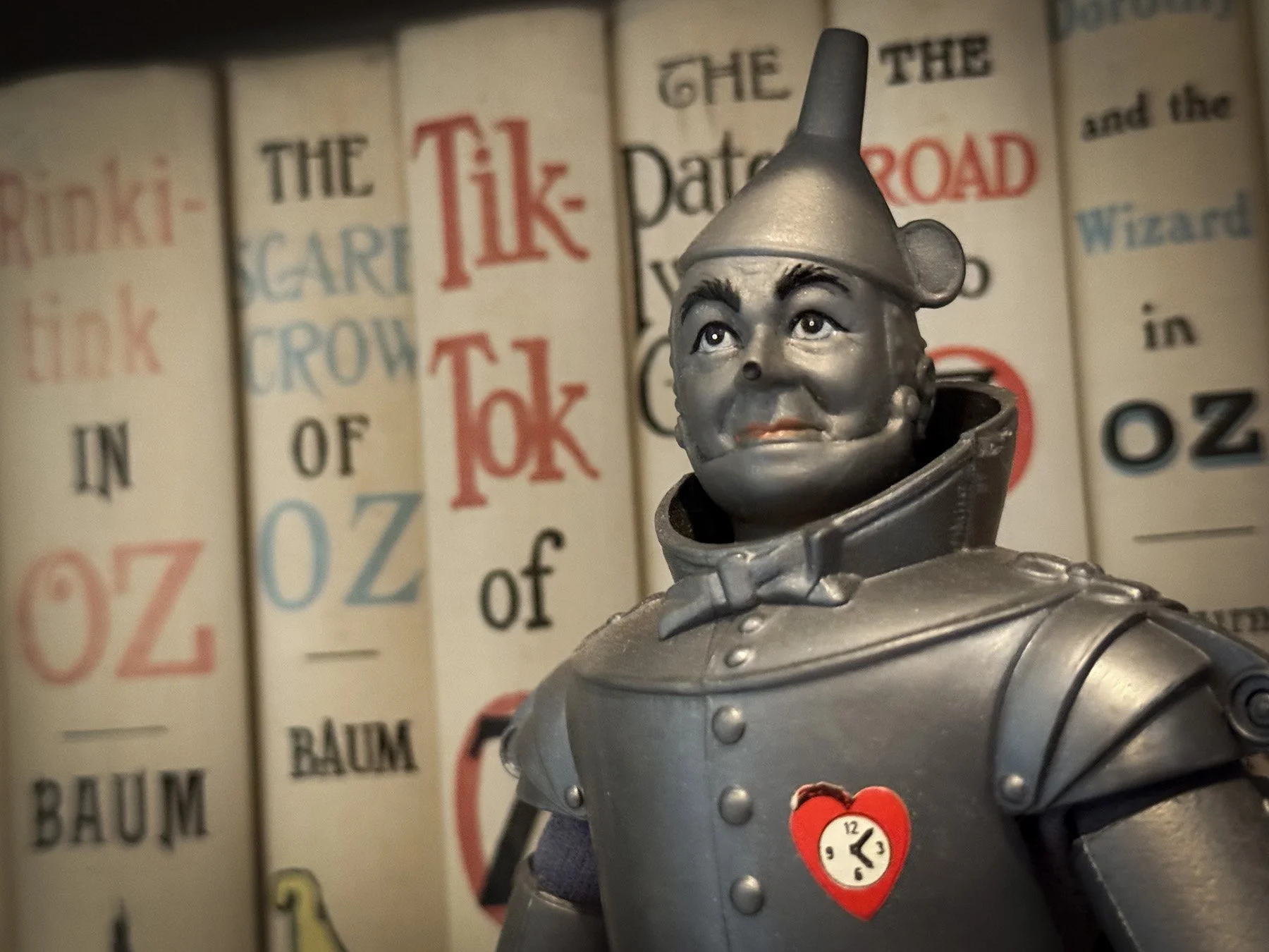 Close-up of a vintage Mego Tin Man figure displayed in front of a vintage Reilly & Lee set of L. Frank Baum's Oz novels, including The Scarecrow of Oz, Tik-Tok of Oz, and The Patchwork Girl of Oz.