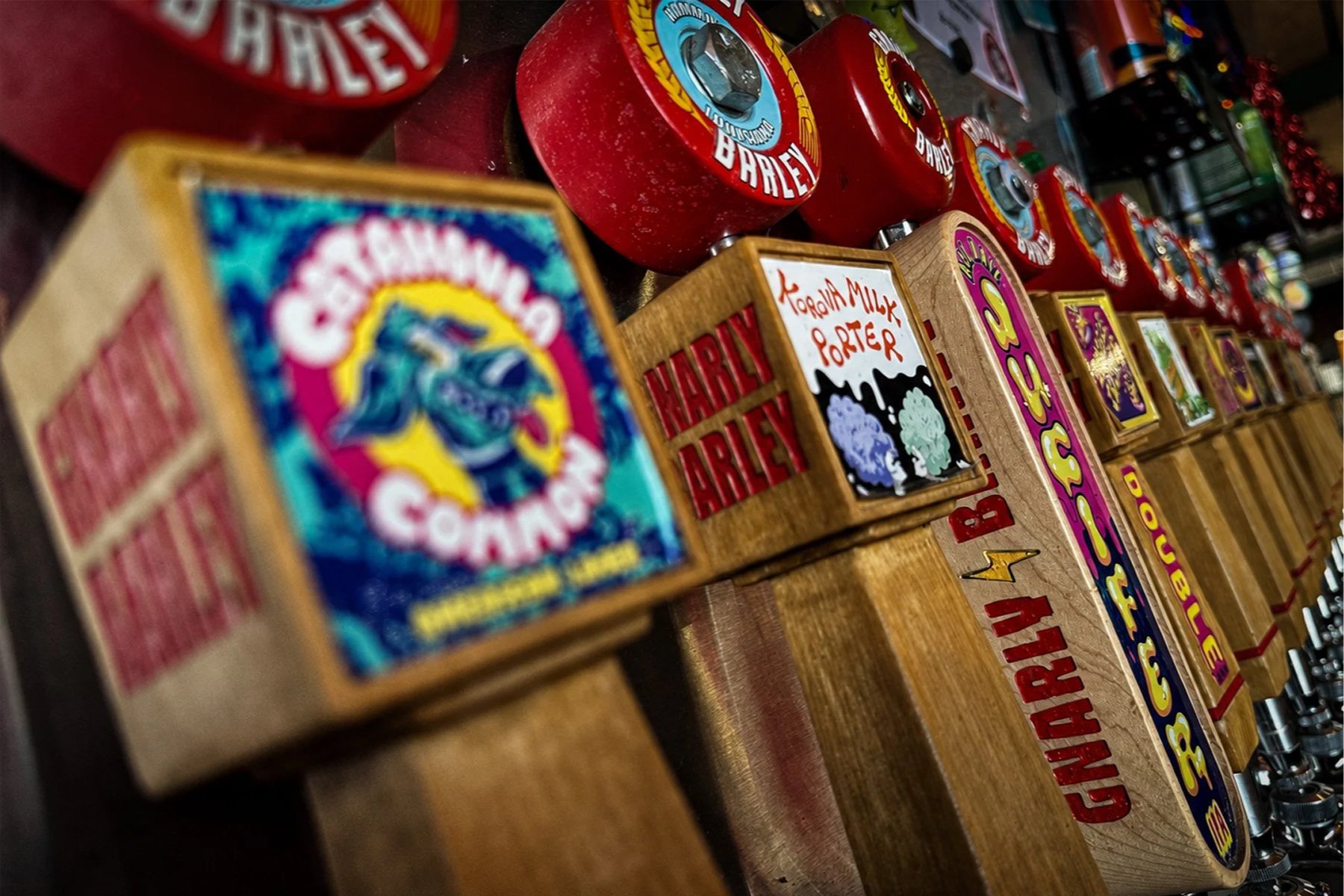 Colorful skateboard-wheel tap handles lined across the bar at Gnarly Barley Brewing.