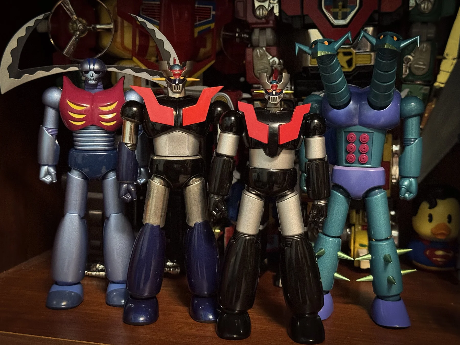 Mazinger Z displayed with Garada K7 and Doublas M2 figures on a shelf in Marco's display room.