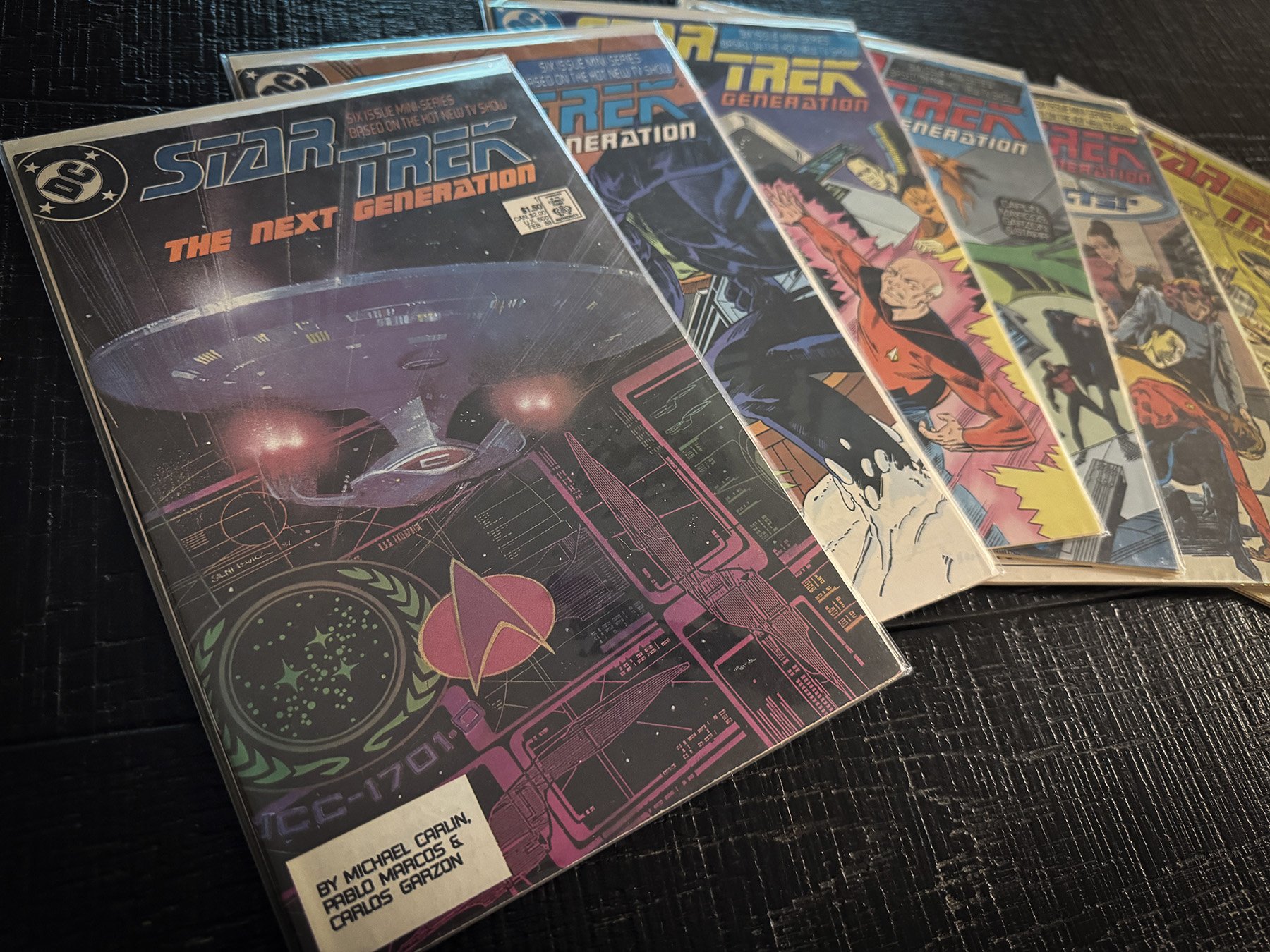 Complete six-issue DC Comics Star Trek: The Next Generation miniseries displayed in protective comic bags, fanned out to show each cover.