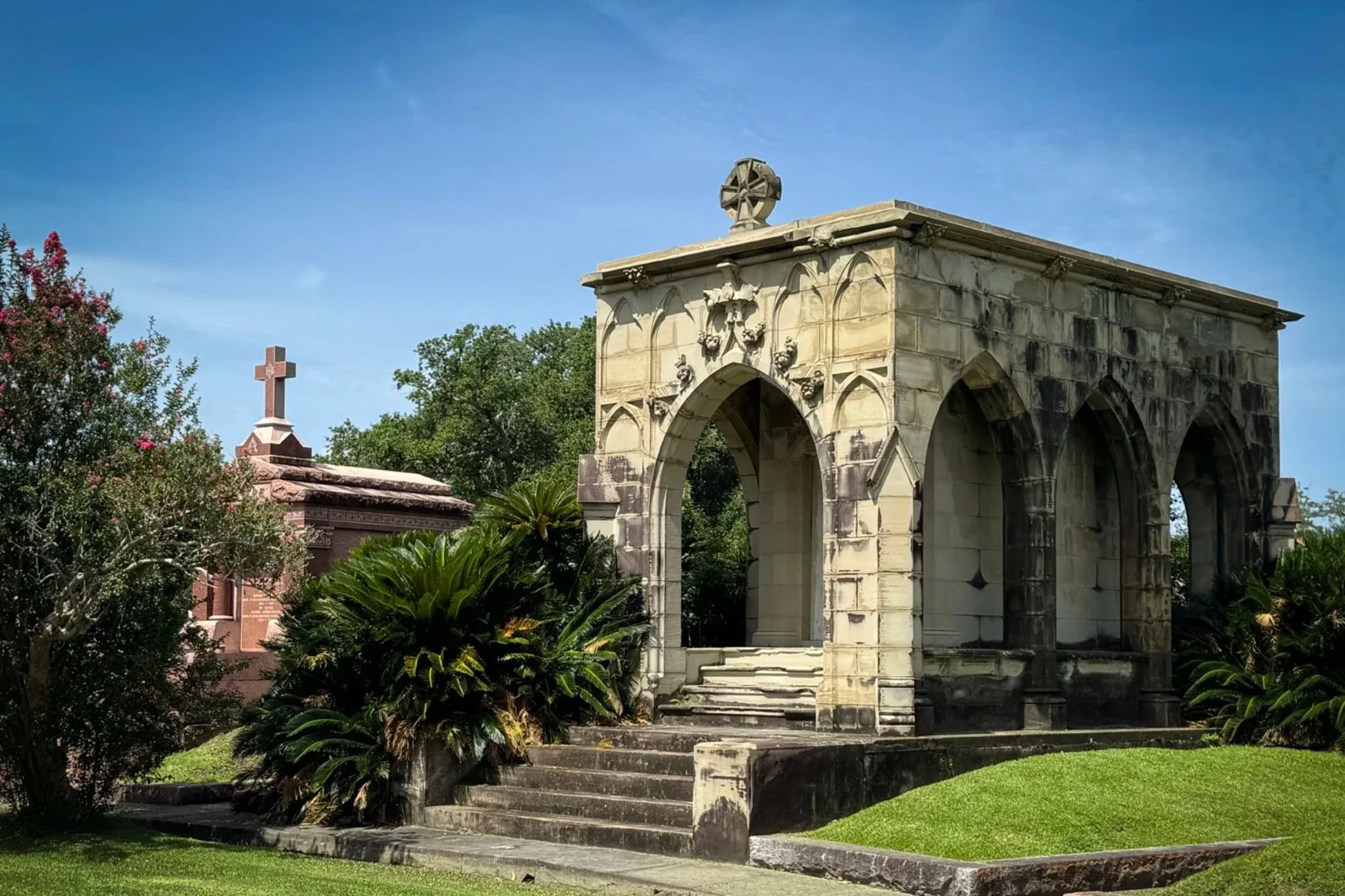 Armant–Legendre family mausoleum with open pointed arches and weathered stonework in Metairie Cemetery, New Orleans.