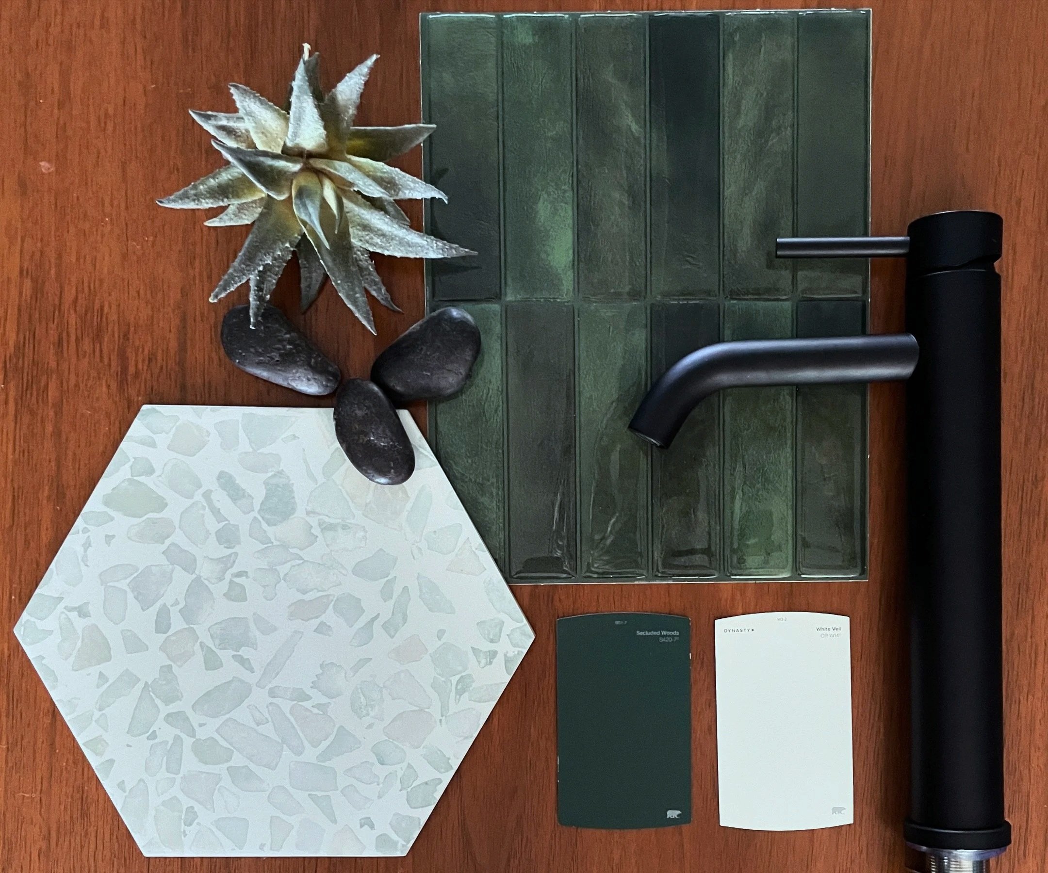 Display of different materials and color options for tiles, including a decorative tile sample in the shape of a snowflake, green textured tiles, and two color options with color name cards.