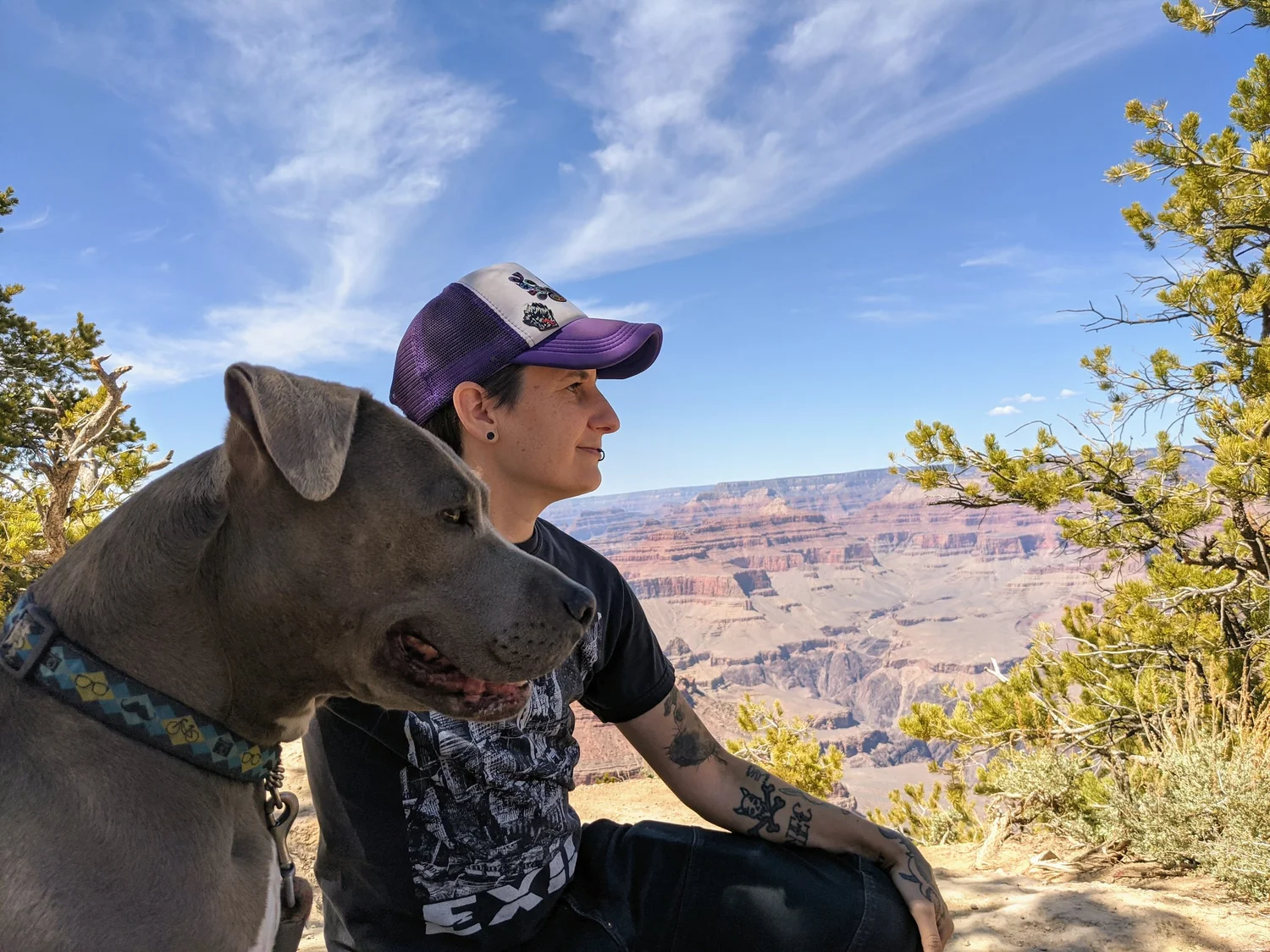 Eli sitting outdoors beside a dog
