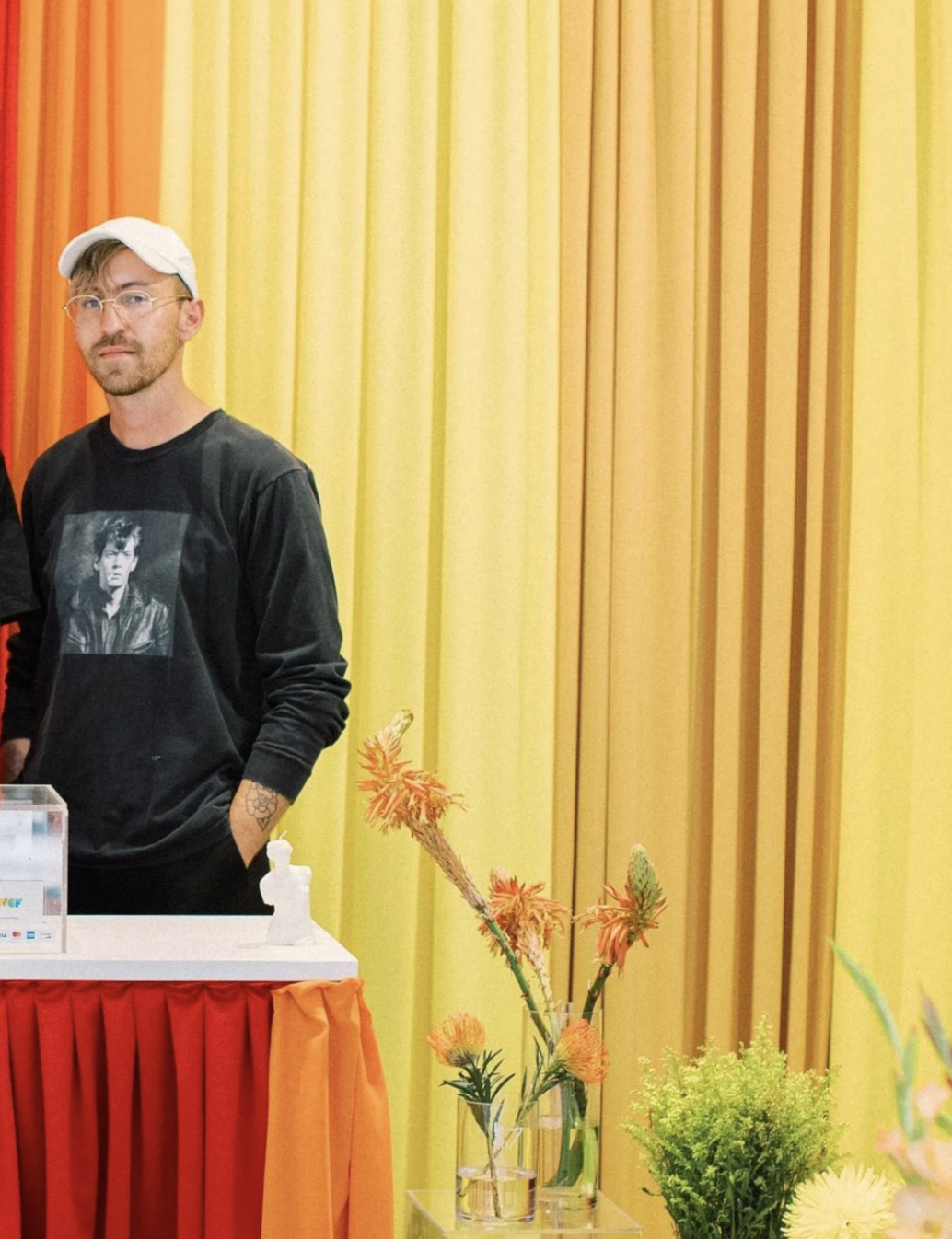 Follin Jeffery of The Boy Who Cried Flowers design an arrangement in front of rainbow fabric wall