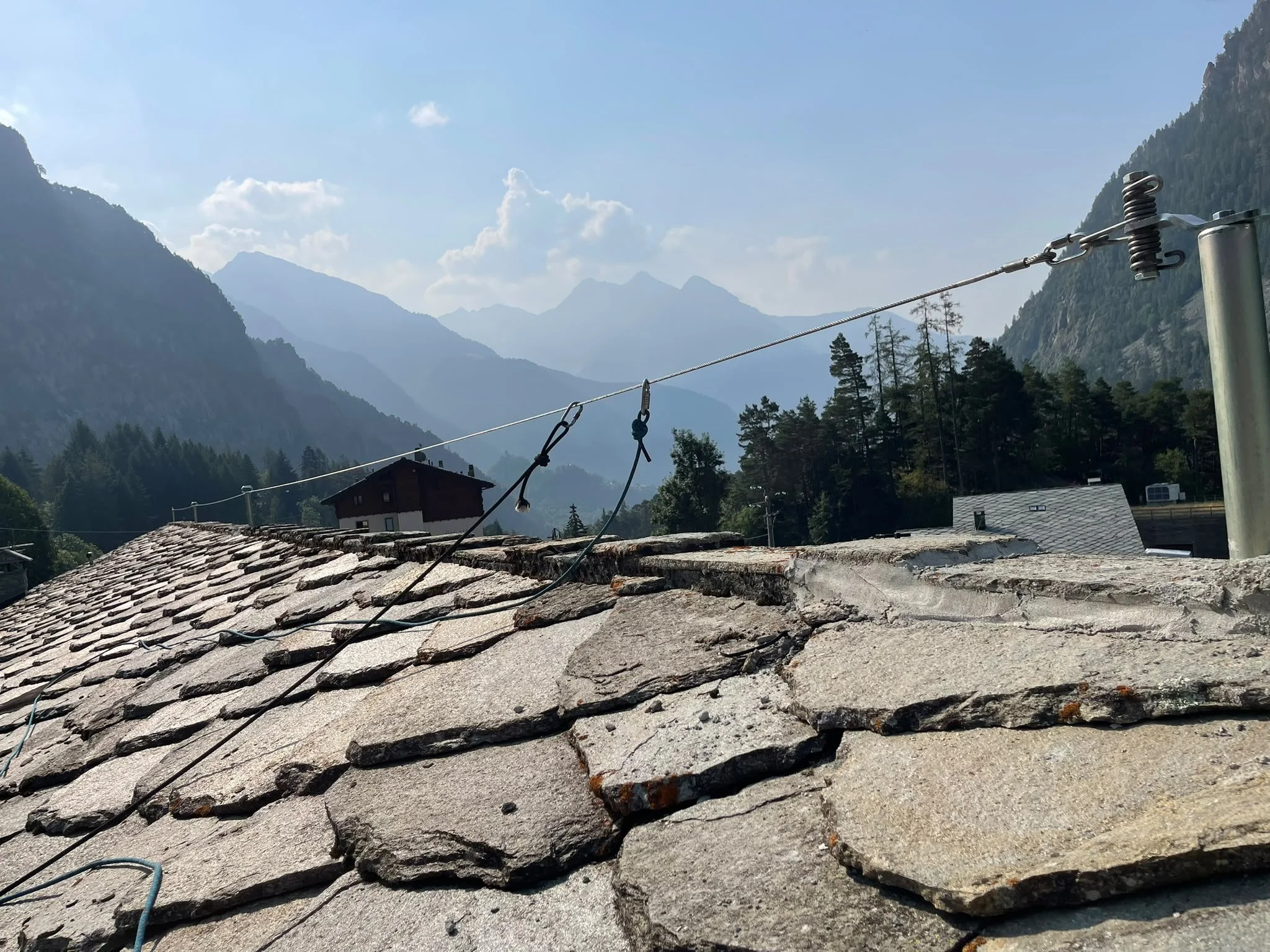 Tecnico durante la posa di un palo di ancoraggio sulla copertura