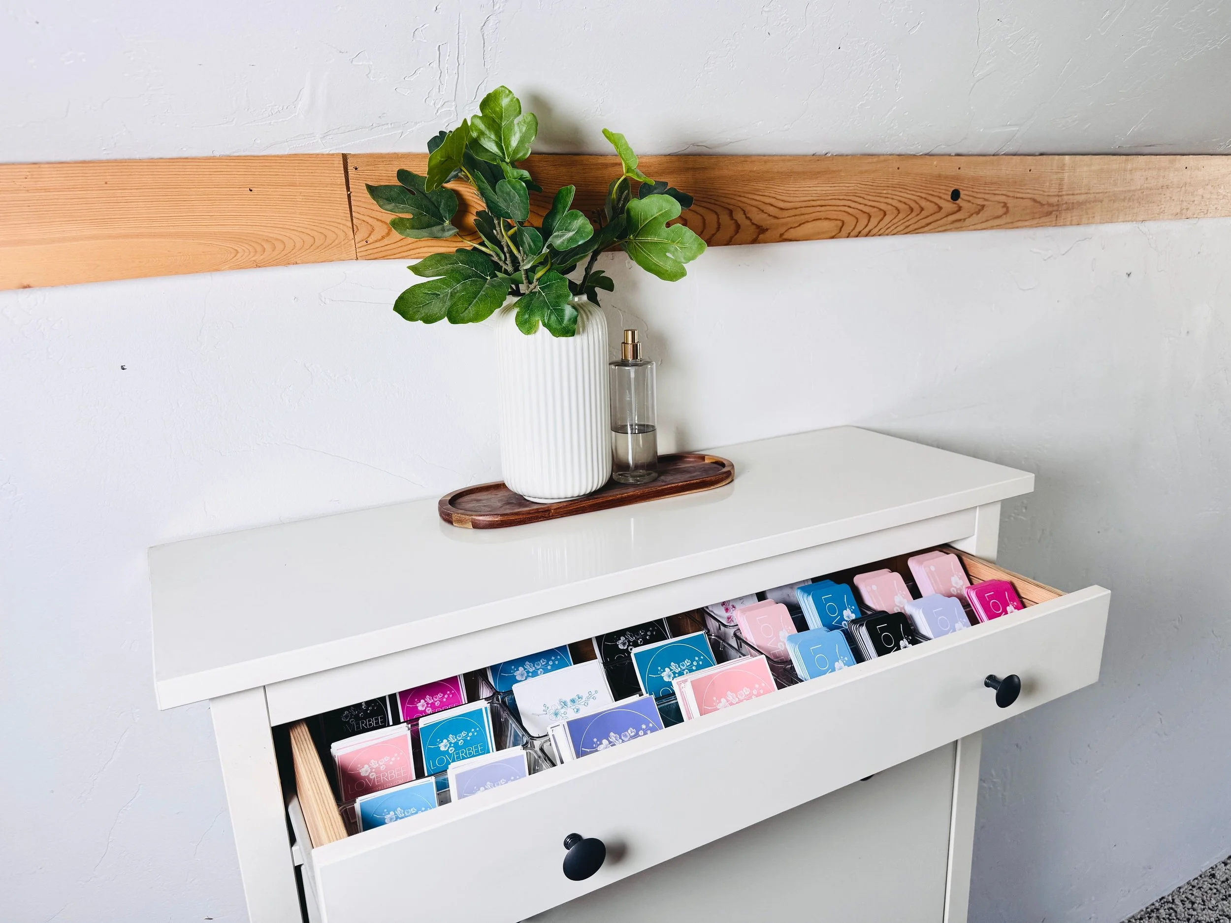 Detailed workspace organization showing business card and sticker storage for a local entrepreneur.