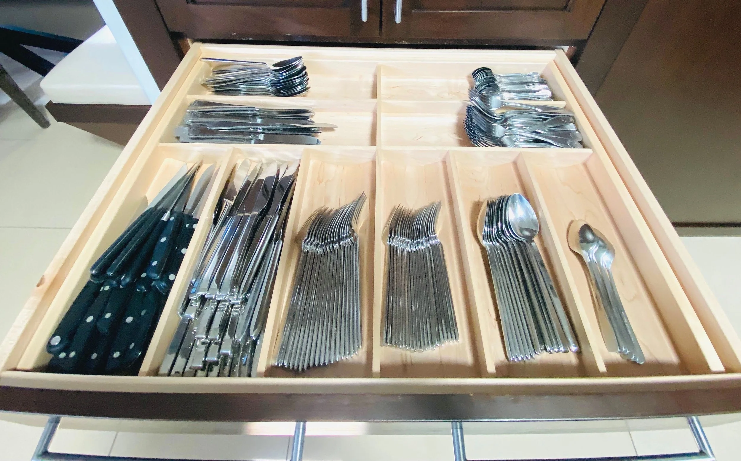 Clean and functional kitchen drawer organization featuring a custom organizer tray for sorted silverware and flatware sets in Park City, Utah.