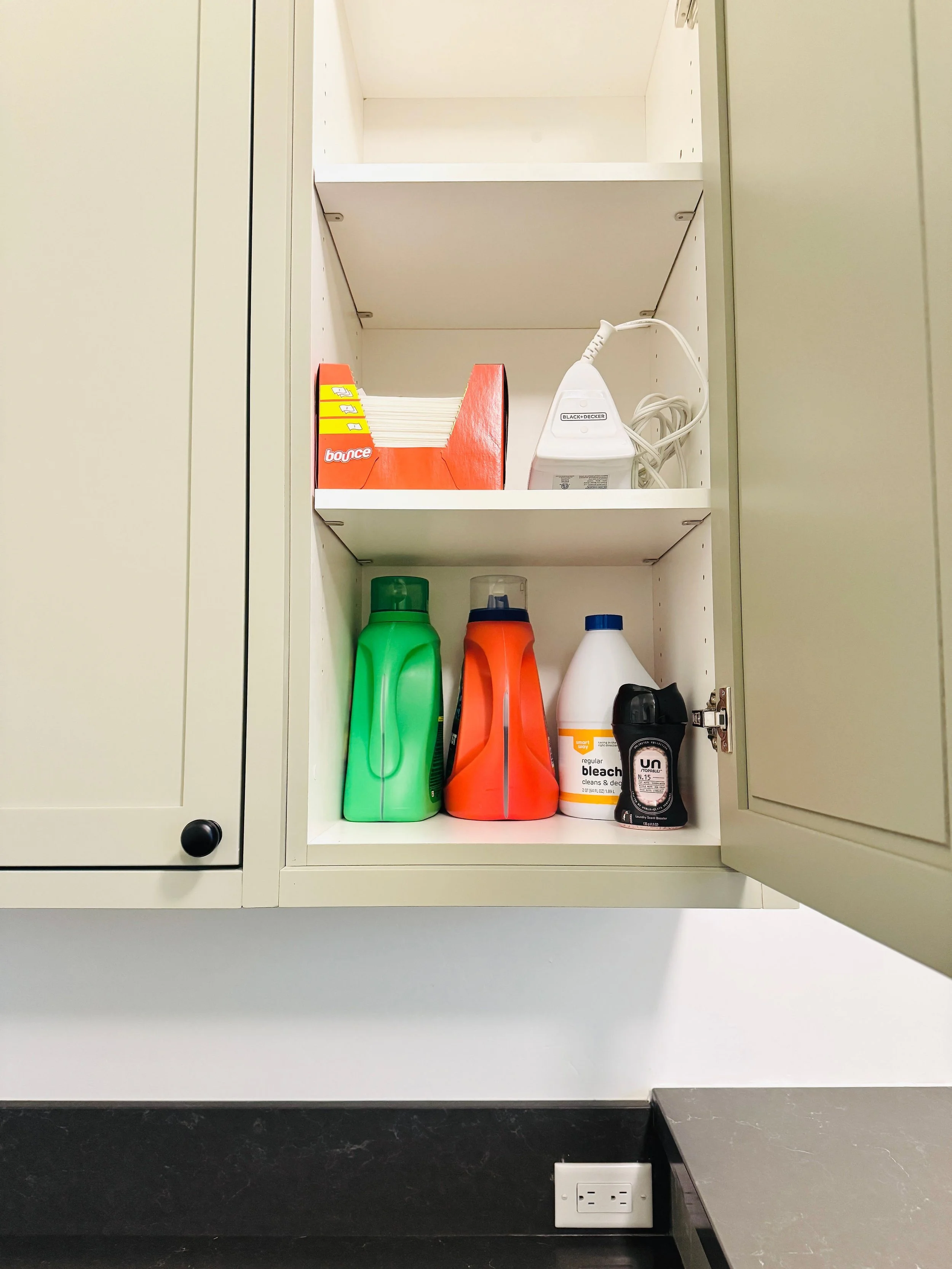 Organized laundry room shelf featuring neat storage for detergent packs, dryer sheets, an iron, and bleach products in a Park City, Utah home.
