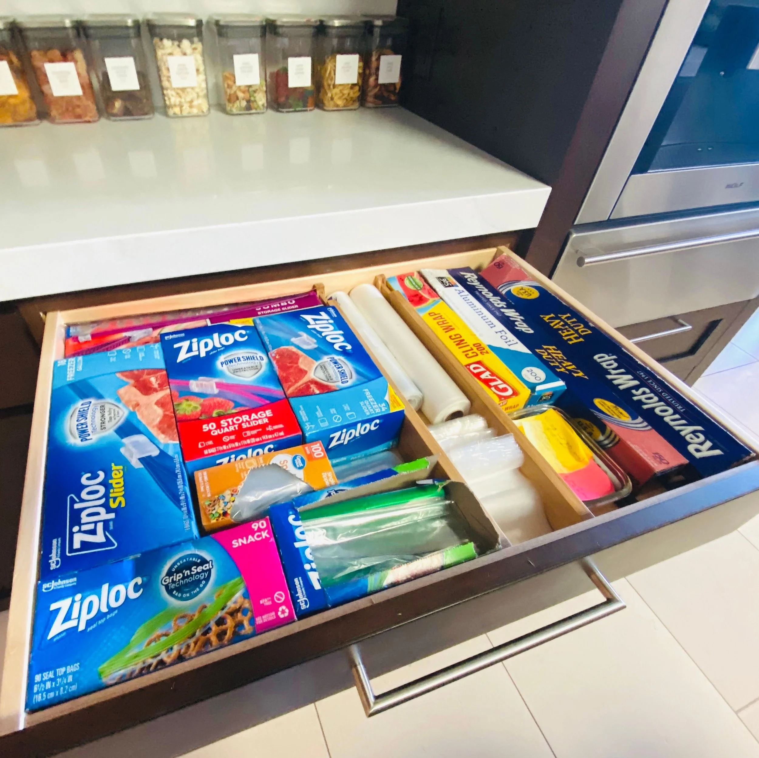 Functional kitchen drawer organization for Ziploc bags, aluminum foil, and plastic wrap.