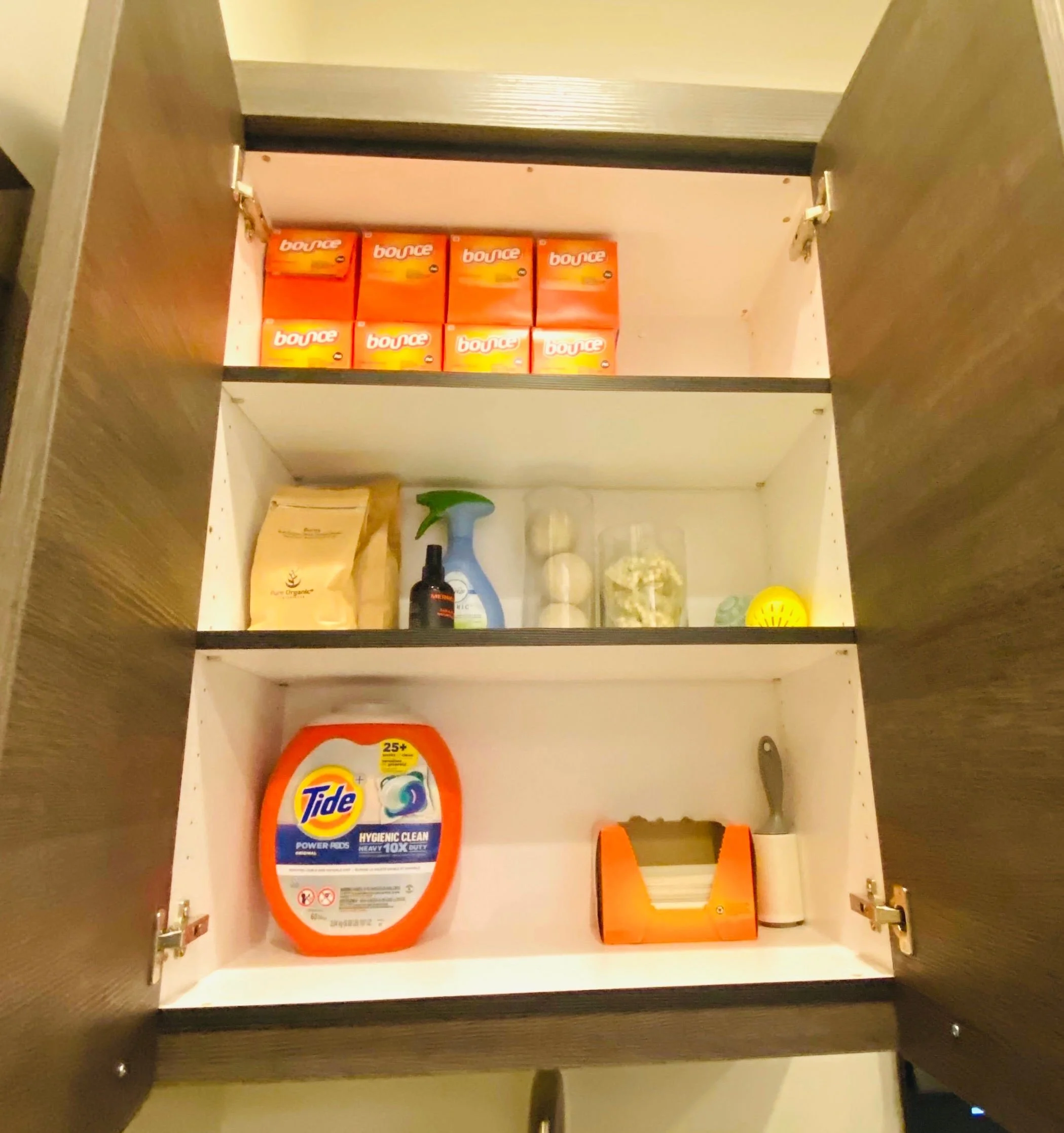 Functional laundry room cabinet organization featuring neatly arranged cleaning supplies, detergents, and household product storage in Park City, Utah.